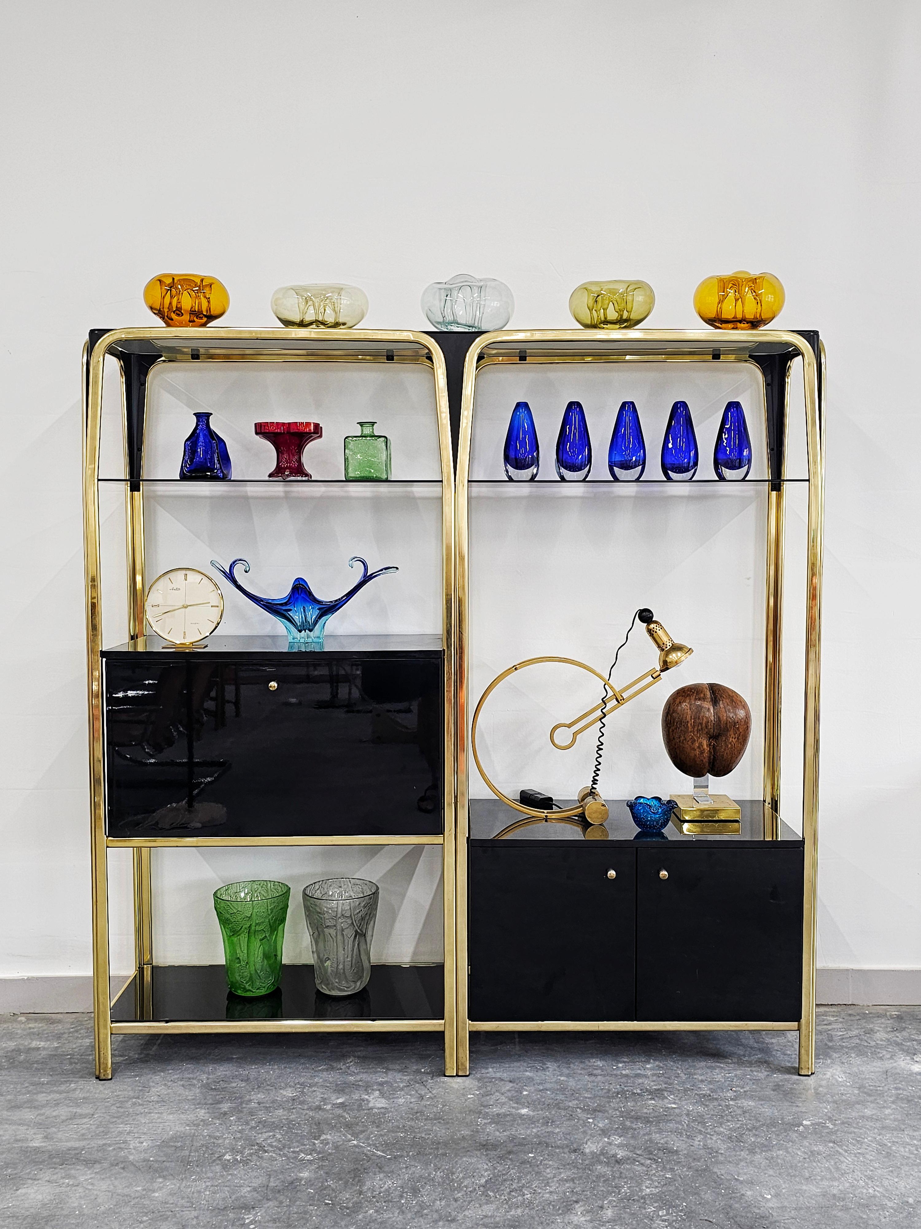 In this listing you will find a spectacular modular wall unit or modular shelving system designed in style of Willy Rizzo and Romeo Rega. It is done in black lacquered plywood, with golden metal construction, creating stark and very elegant