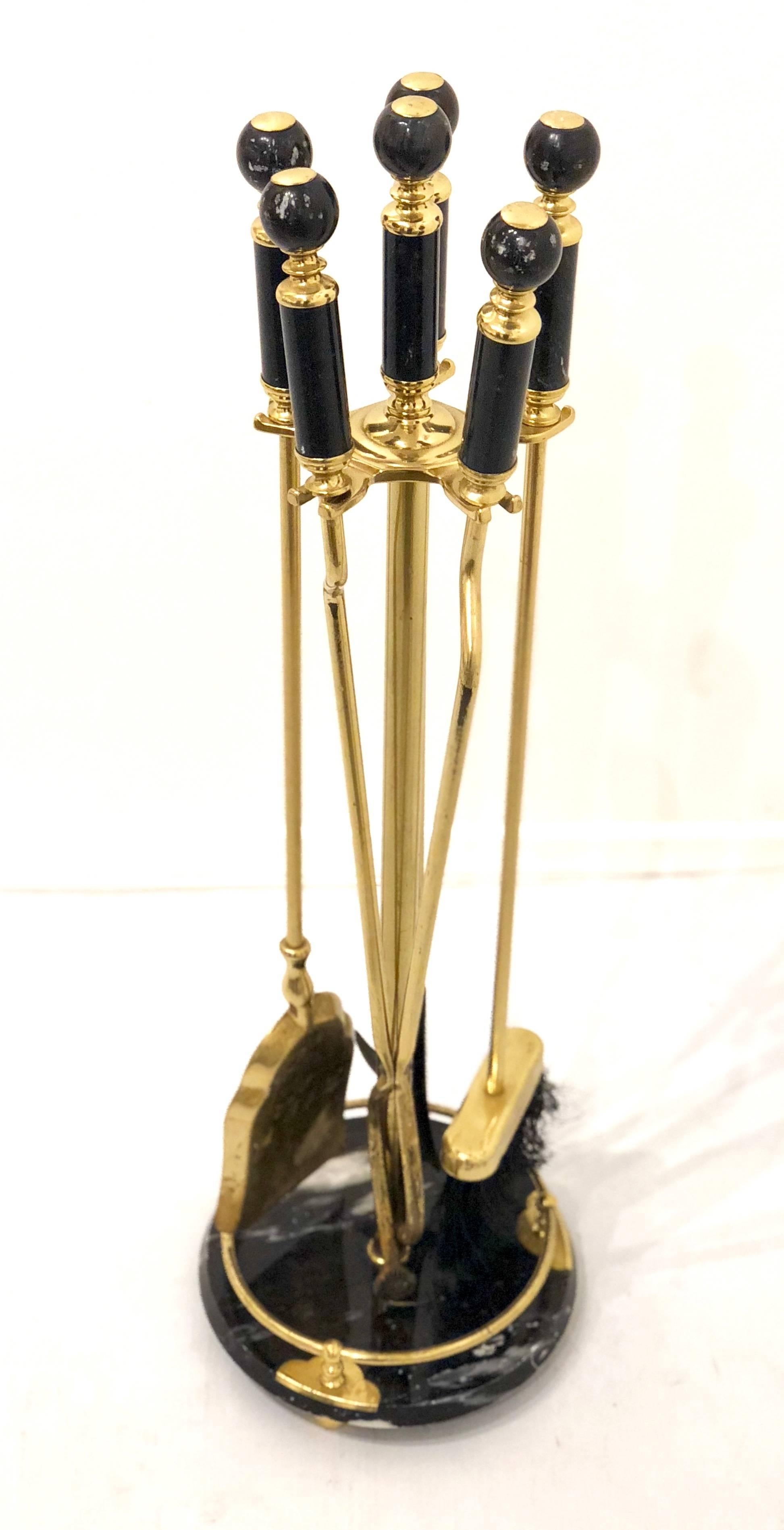Elegant brass fireplace tool set with black marble base and handles, circa 1970s. Amazing quality; very heavy with nice detail on the handles. Set includes a shovel, brush, poker and log holder.