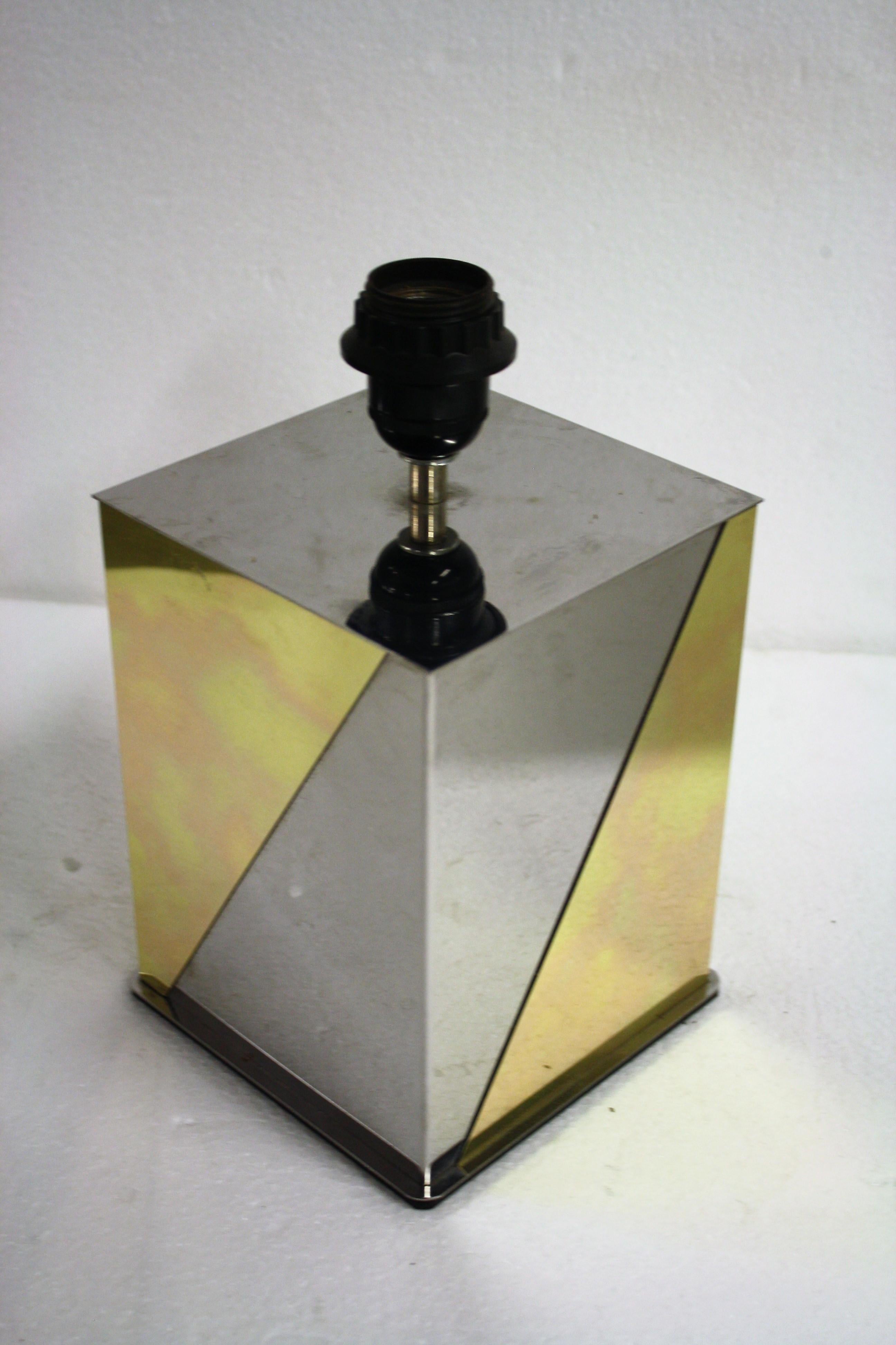 Mid-Century Modern two-tone brass and chrome table lamp.

The square table lamp has a three dimensional effect as seen in the first pictures.

It comes with a square fabric shade with a silver finish.

The lamp has been tested and can be used