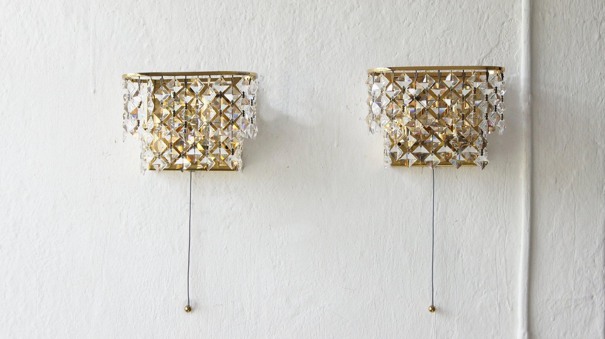 Paire d'appliques en cristal de Palwa.
Il s'agit d'une proposition d'éclairage décoratif pour des intérieurs sophistiqués dans le style Hollywood Regency.
L'élégance de la lampe est assurée par la finition en laiton et la plus haute qualité des