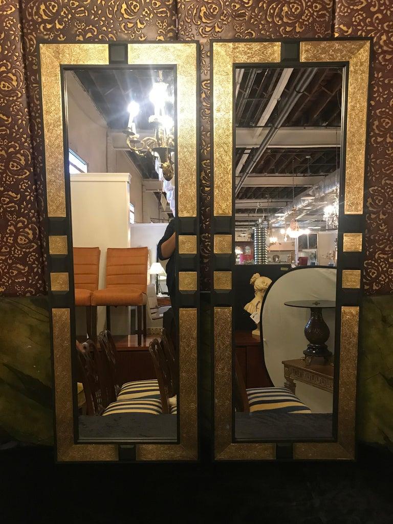 Pair of Hollywood Regency gold brass and ebony wood framed pier or console mirrors. For those looking to add a little regal decor to their home, our golden mirrors may just be the accent piece that delights. The frame is handcrafted with gold brass