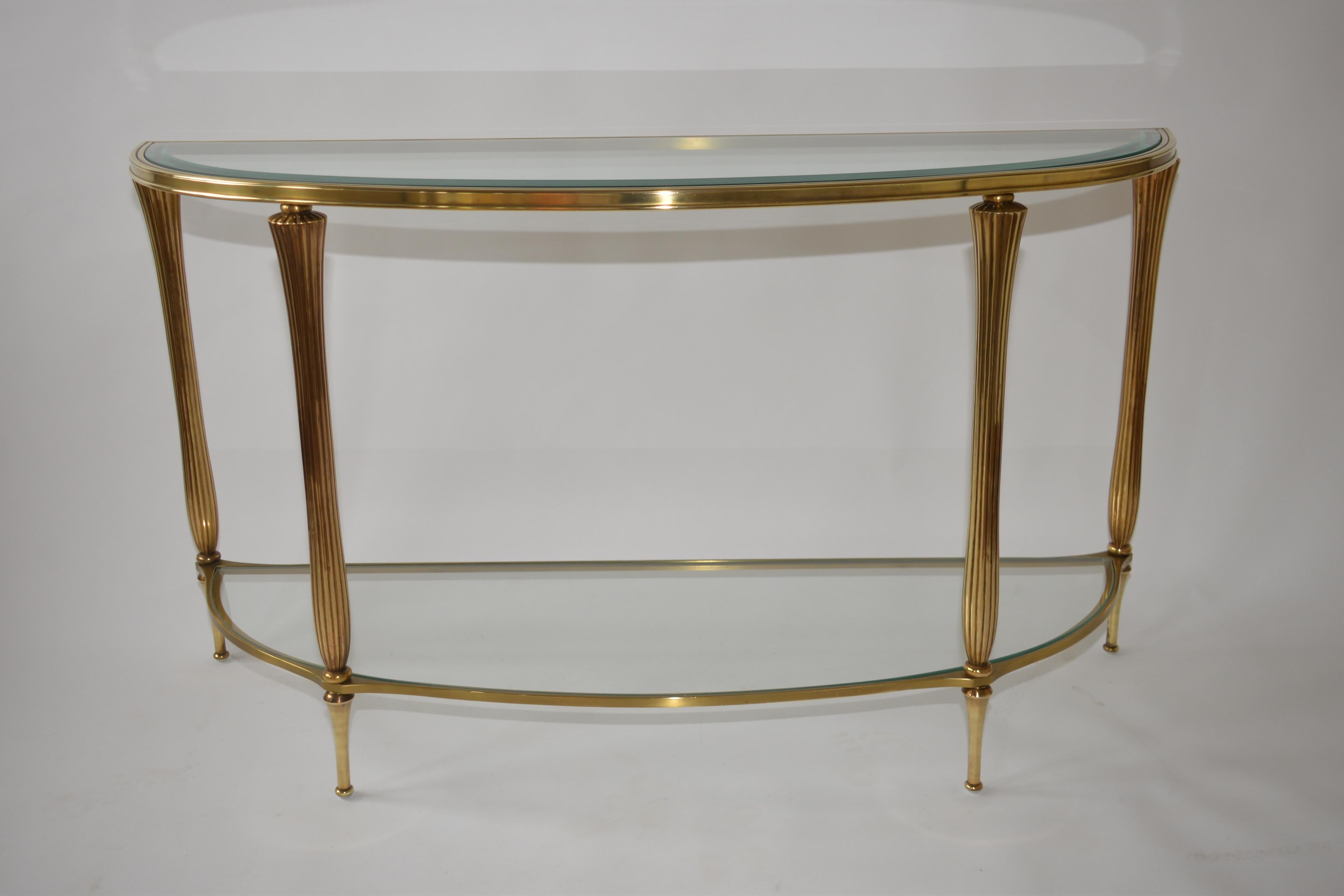 A fabulous Ethan Allan brass and glass half oval console table. A very striking item with two tier glass shelves. In the style of Hollywood Regency and in excellent condition.