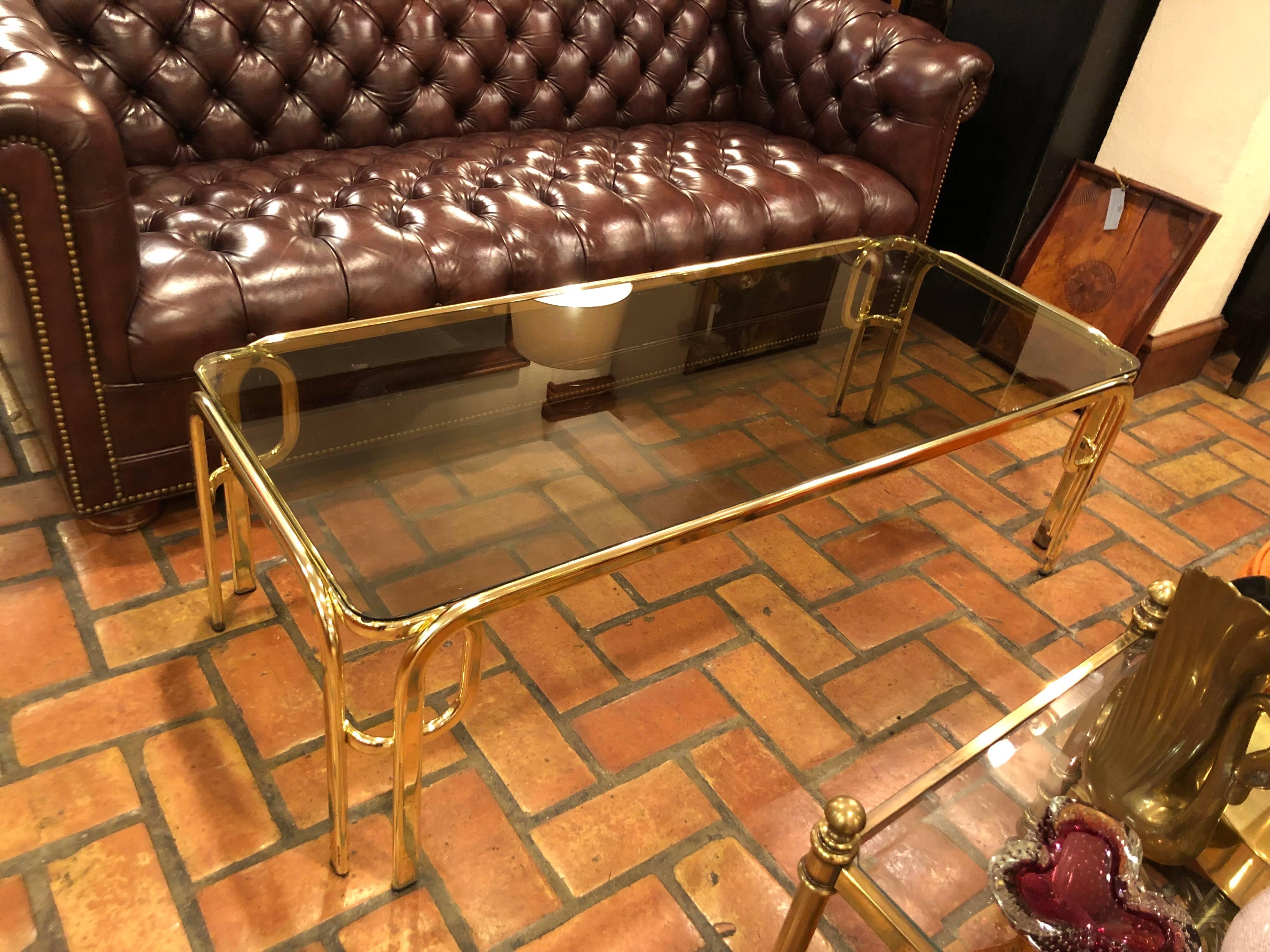 Hollywood Regency brass and smoked glass coffee table. Sleek, sexy lines make up this beauty.
 