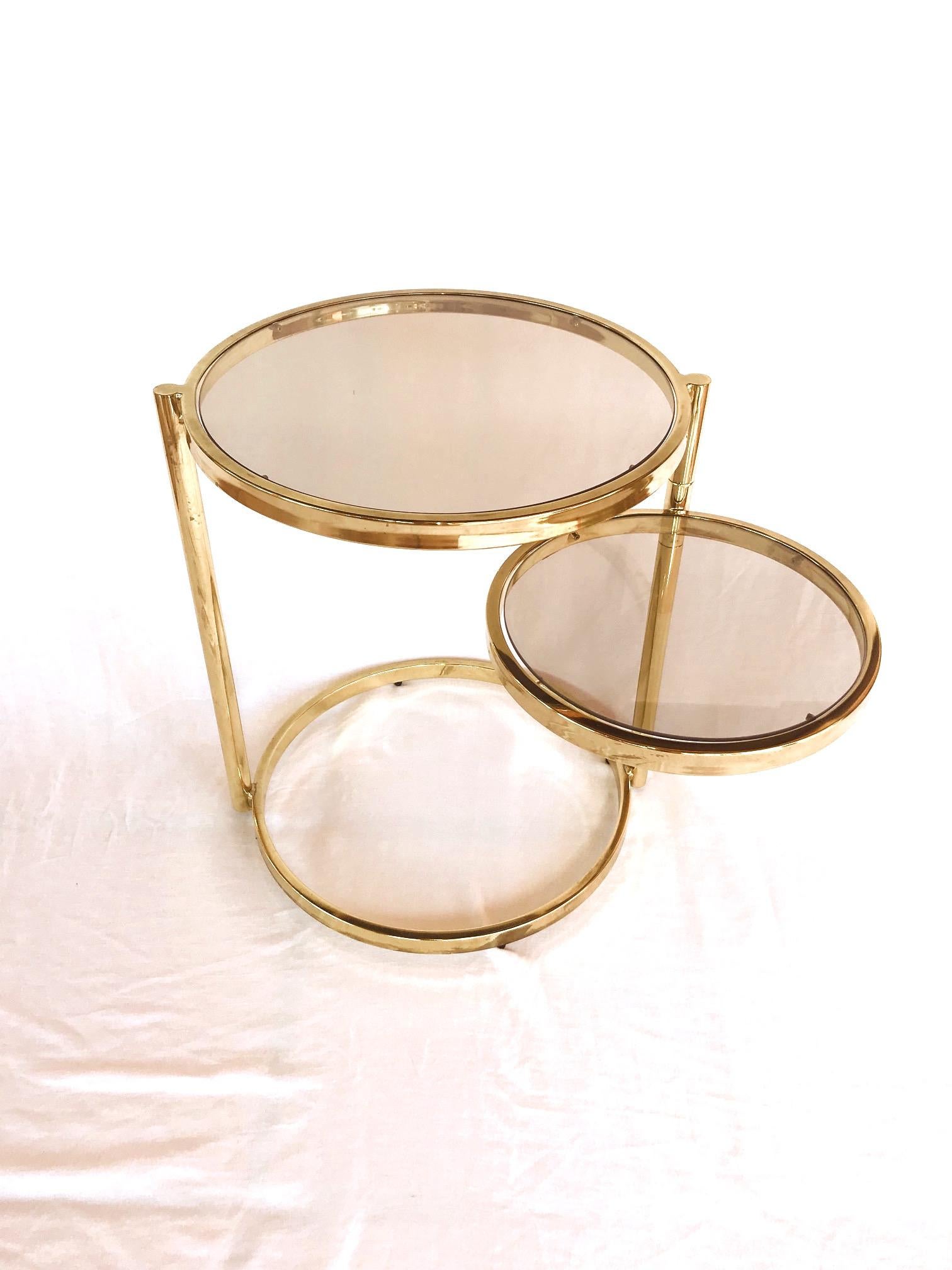 Mid-Century Modern two-tier side table with extendable top. Brass frame with adjustable and rotating second tier allowing the table diameter to extend from 19.5