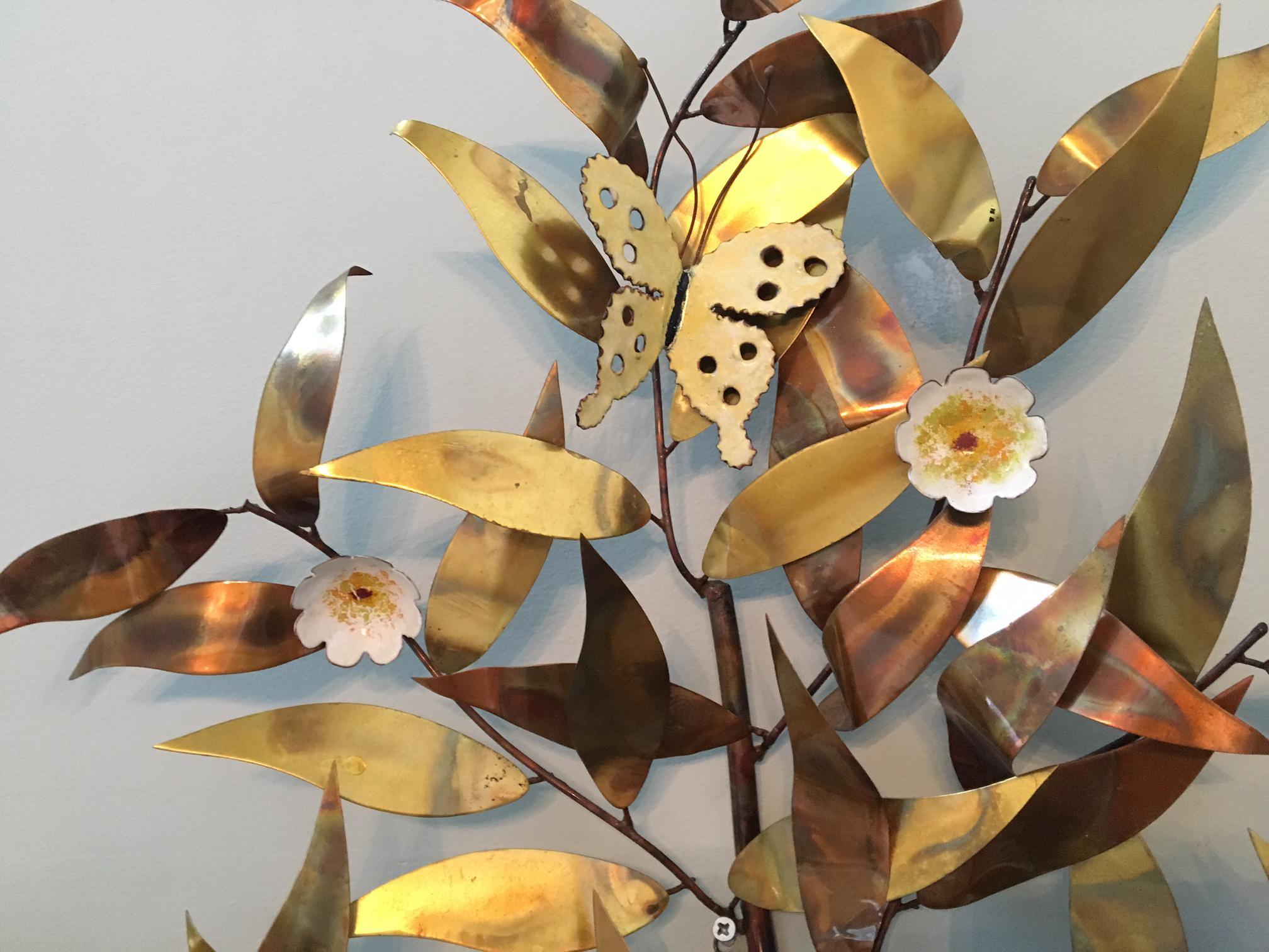 Metal wall art features brass colored leaves and tole style flowers and butterflies. Signed by artist 