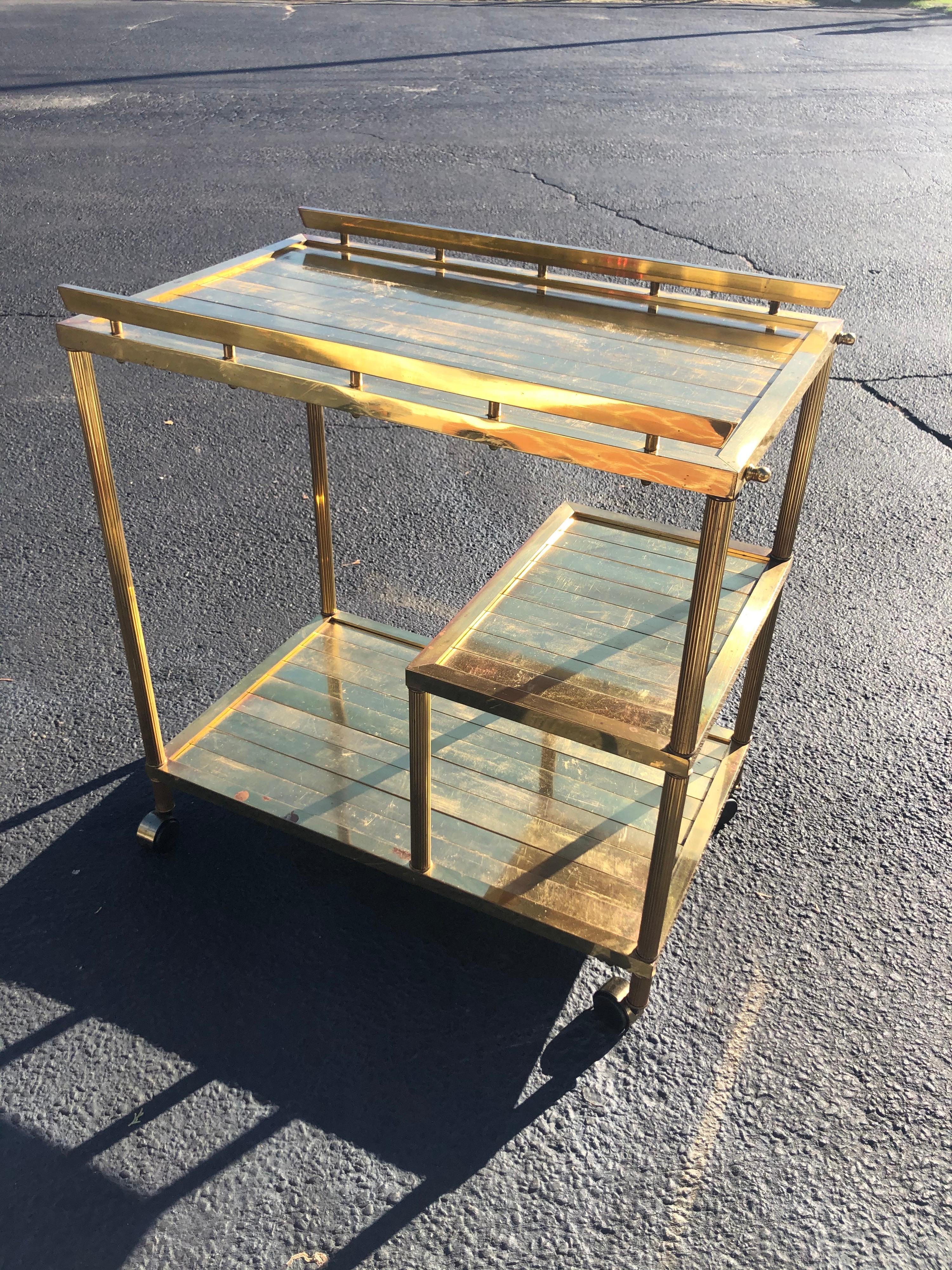 Hollywood Regency brass bar cart. Custom made in the 1970s by a brass importer of Italy. Three shelves. Constructed of brass bars in formation. Heavy weight. Not recommended for rolling around as one wheel does not articulate well. Trying to replace