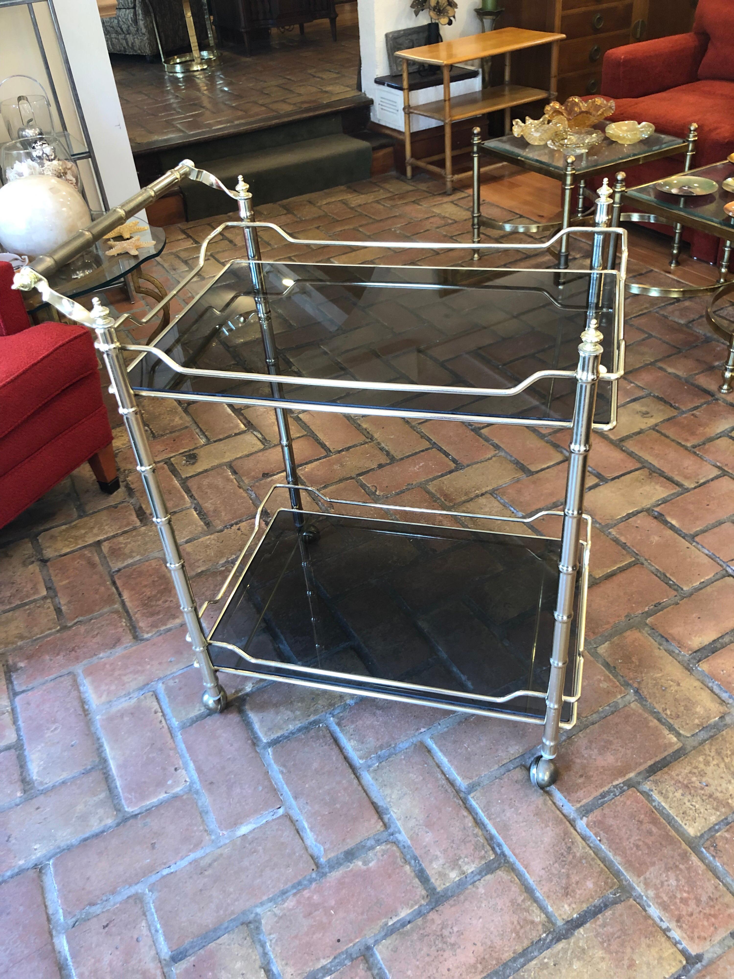 Hollywood Regency brass bar cart with smoked glass on wheels. Sleek and sexy.