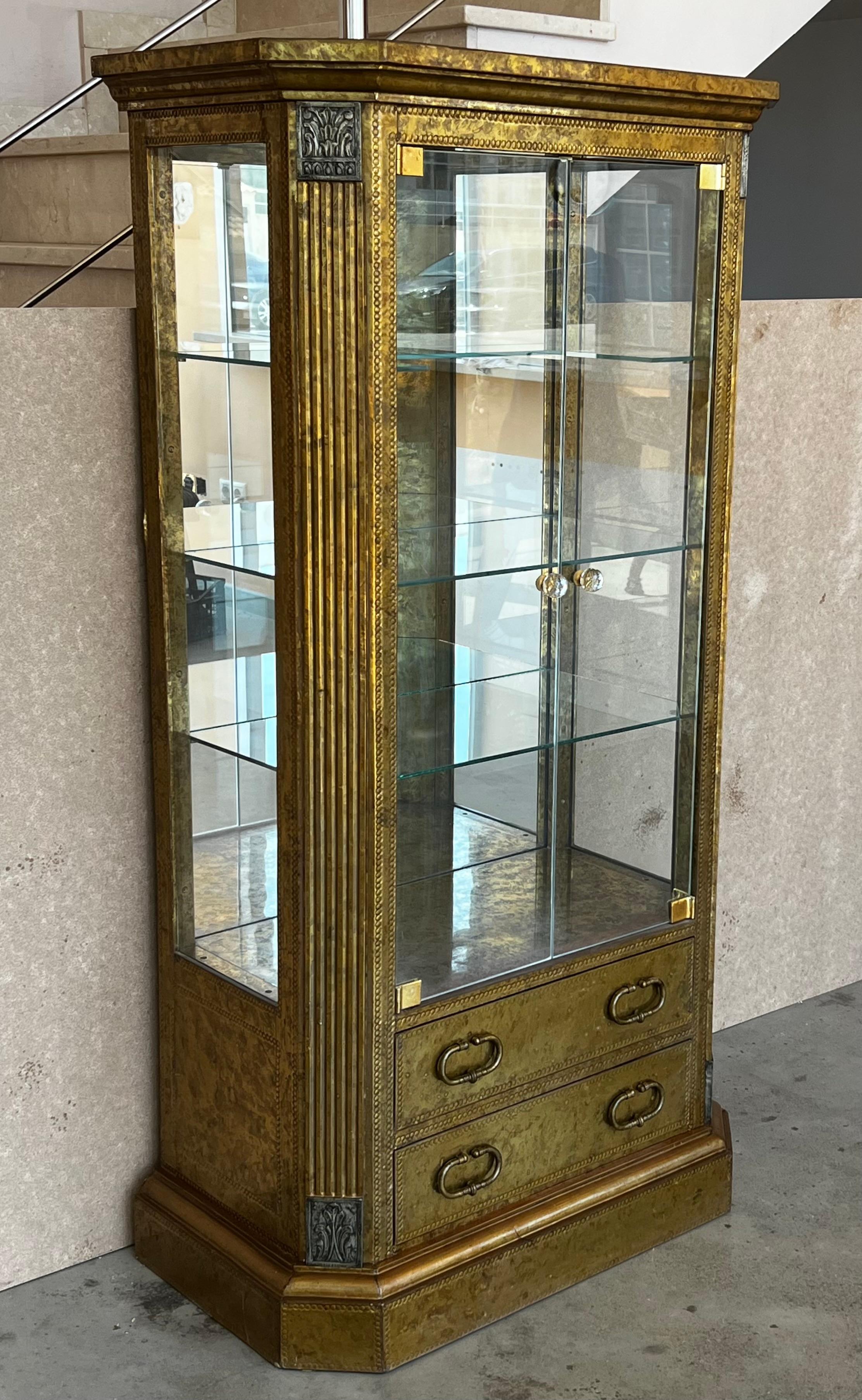 Mid-Century Modern drinks bar cabinet with nice brass faces with hammered brass nails, panels in a solid wood frame.
This piece its from the 1960s, beautiful oxidation that opens up completely.

The interior has three glass shelves and two