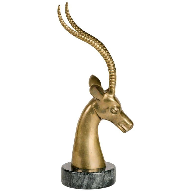Mid-Century Modern hand forged sculpture of stylized gazelle or ibex. Minor patinated spots on brass adds to its vintage beauty. Features a hand polished exotic marble base in hues of black and grey.