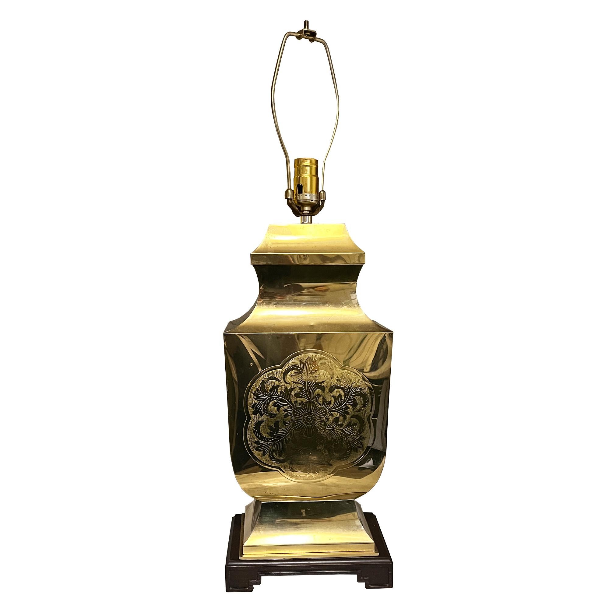 Bring timeless elegance and warm sophistication into your home with this vintage brass chinoiserie table lamp, beautifully crafted with an etched floral medallion design on its front panel. Resting on a classic carved wood base, this lamp captures