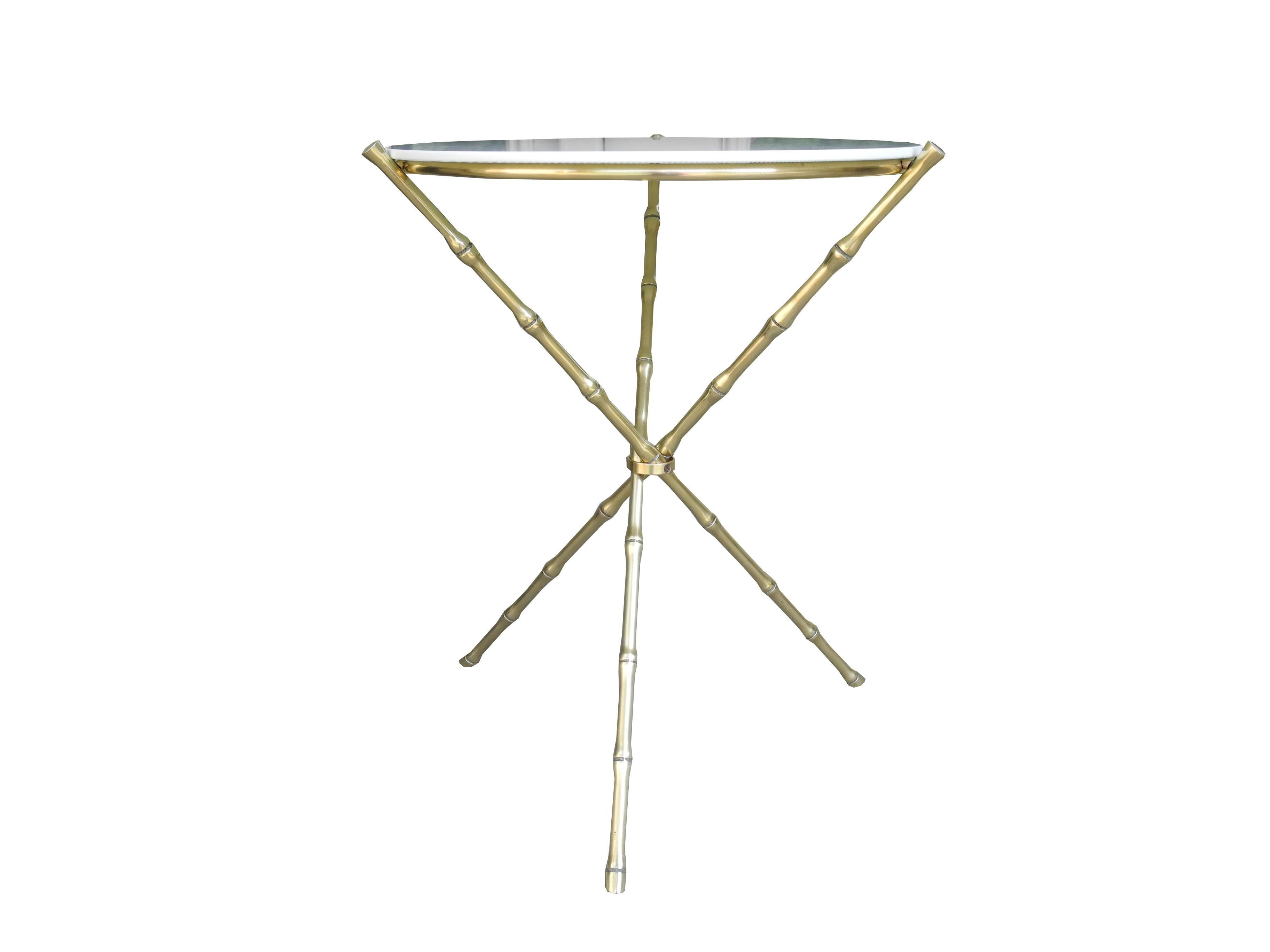 This elegant tripod side table is made of solid brass shaped like bamboo and topped with the original white milk glass. The glass is in excellent condition. No chips. The style is Hollywood Regency in the manner of Maison Baguès.