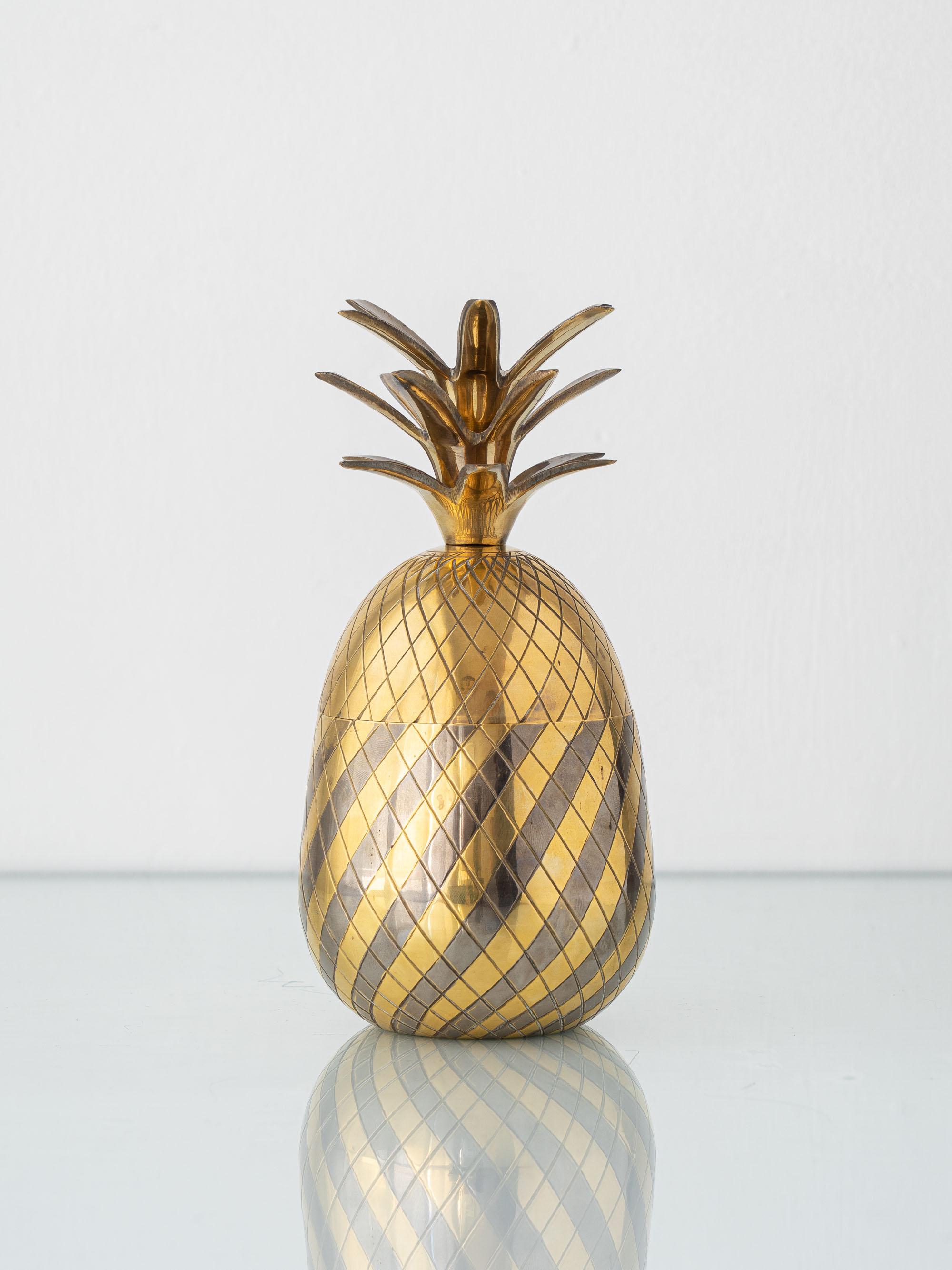 A sculptural mid-century pineapple ice bucket in solid brass, produced in Europe between the 1960s and 1970s. The piece is crafted from spun brass with a finely engraved cross-hatched pattern that creates the classic pineapple texture. The removable