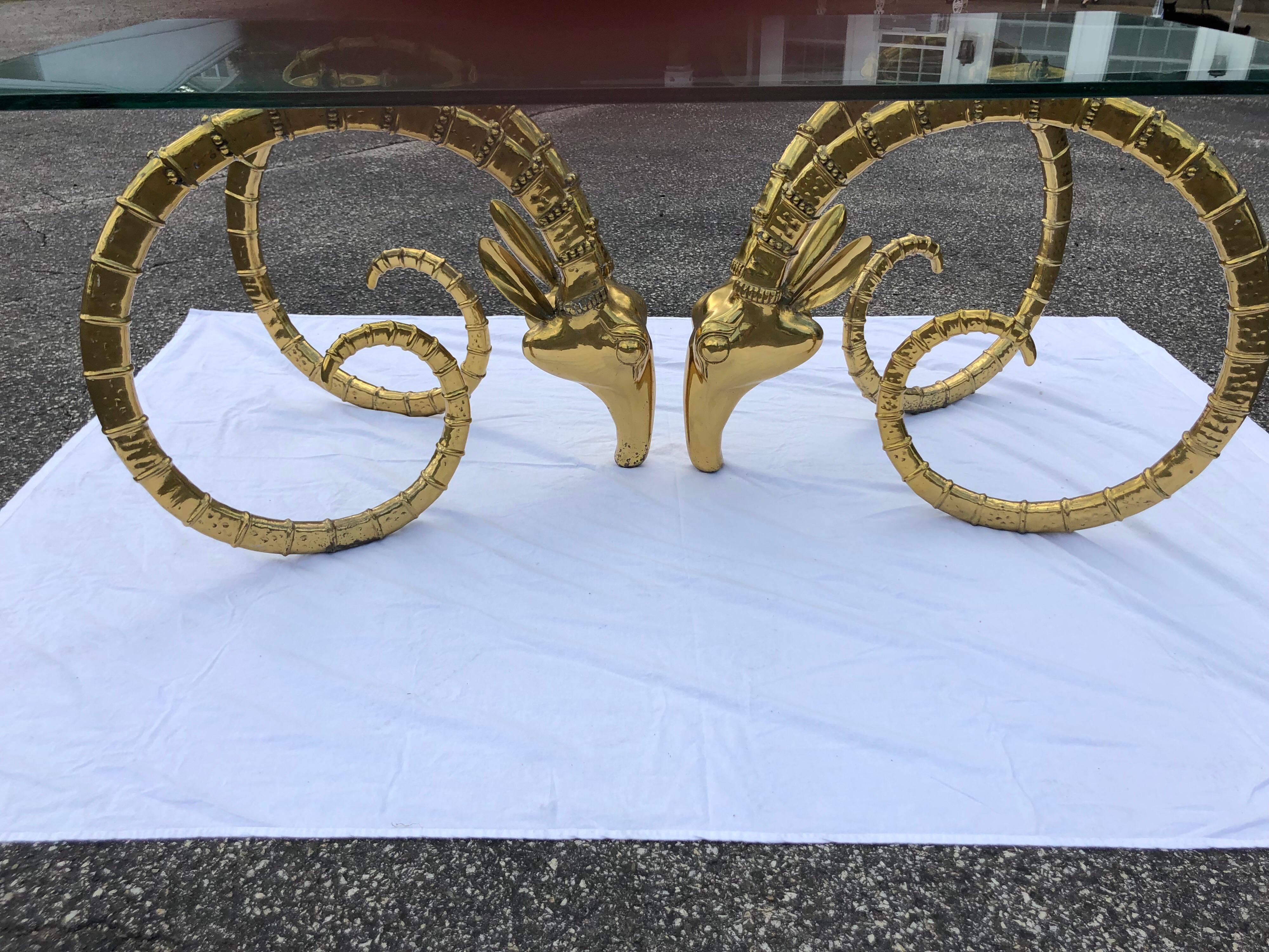 Hollywood Regency brass ram head dining table in the manner of Alain Chervet. Amazing detail to these heavy ram or ibex heads in brass . Detailed trim and amazing patina make up this spectacular design statement. Your guest will love to dine on this
