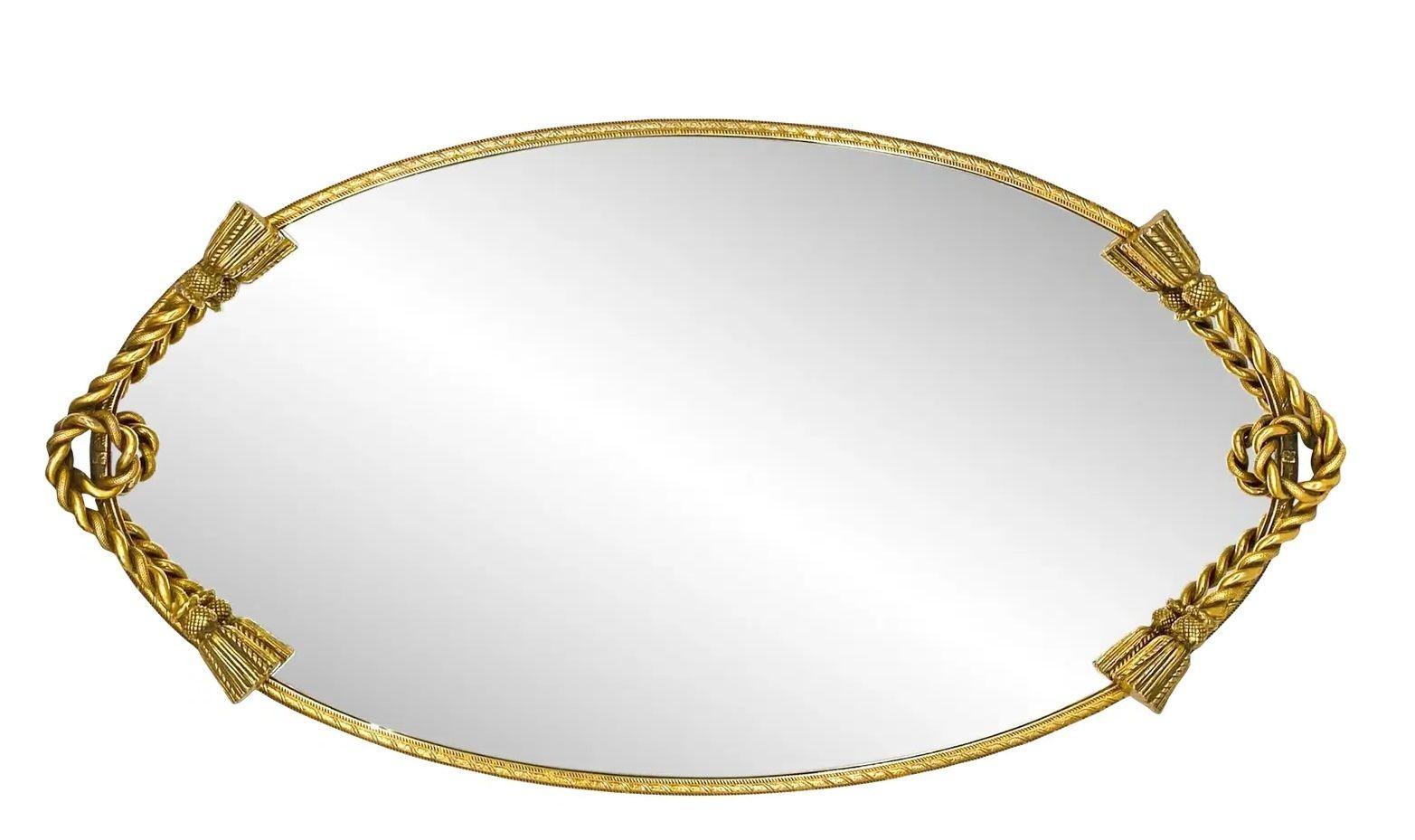 Vintage Hollywood Regency Oval Vanity Tablett mit vergoldetem Seil und Quaste Detail, c. 1950s
Dieses elegante und raffinierte Hollywood-Regency-Tablett aus der Mitte des 20. Jahrhunderts strahlt mit seiner ovalen, verspiegelten Oberfläche, die von