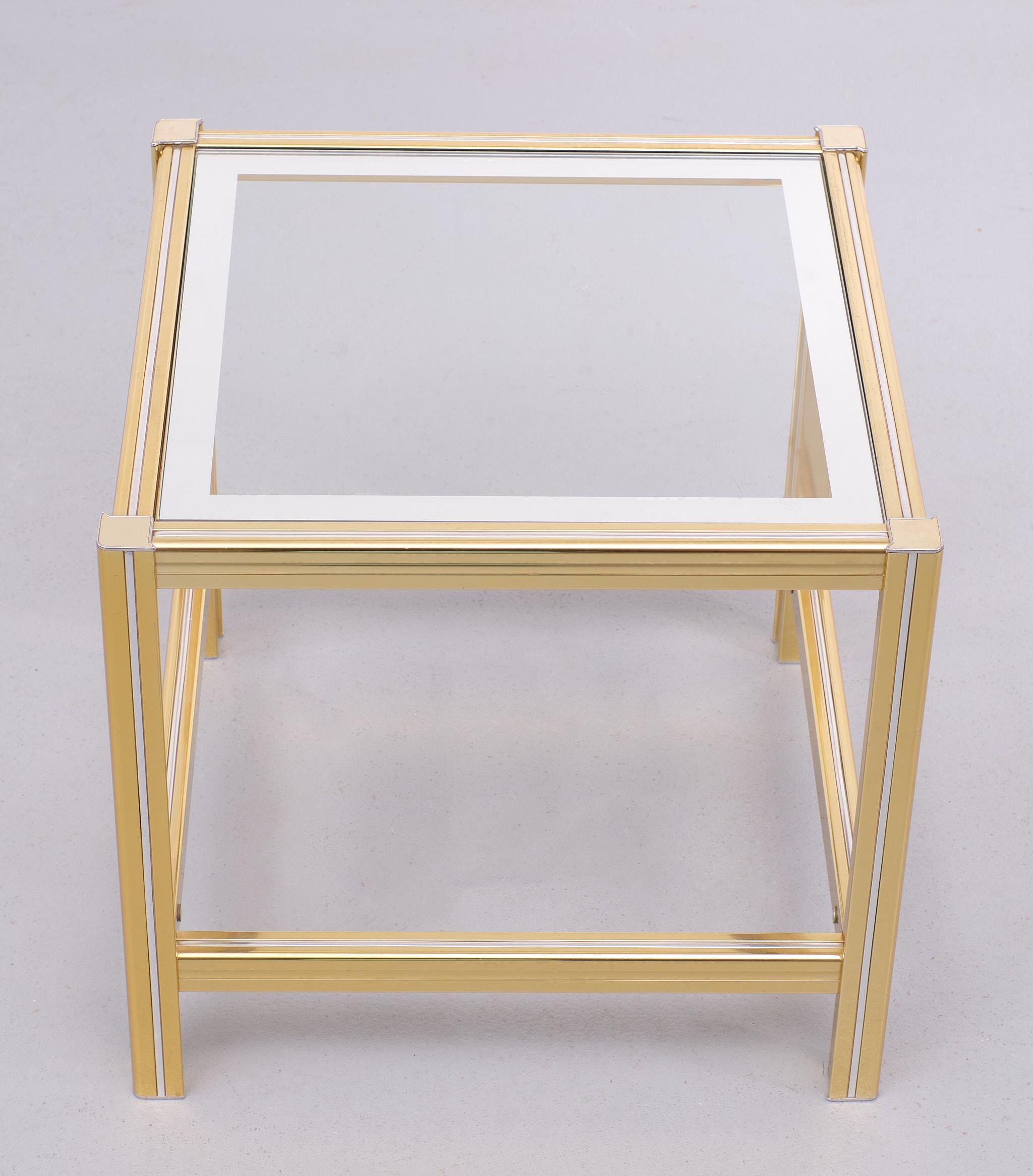 Very nice Hollywood Regency side table or end table. Brass with Chrome inlay,
comes with its original glass top with mirror lining. Good condition.