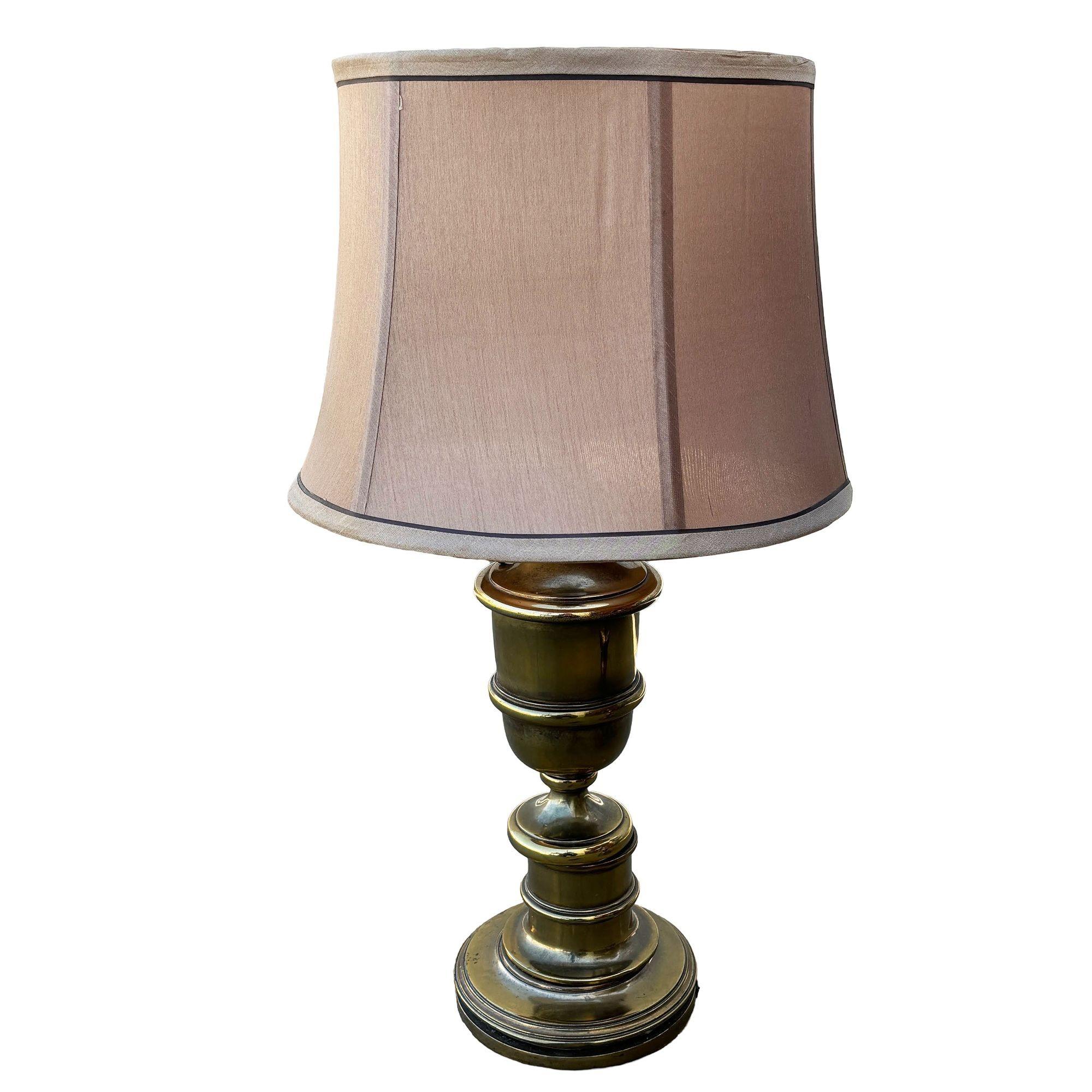 Hollywood Regency Stiffel Style Brass Table Lamp with original Shade. The lamp features a all brass with a 120v US standard socket and plug with a 6-sided fabric shade. Illuminate your space with a touch of classic elegance with this mid-century era