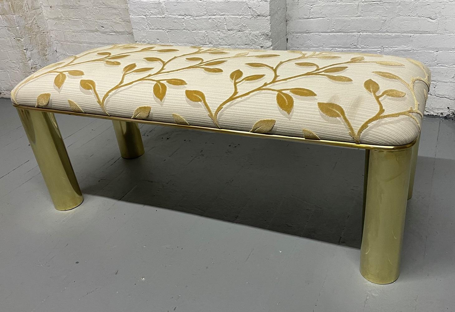Karl Springer brass and upholstered bench. The bench has brass cylindrical legs with the original floral fabric.