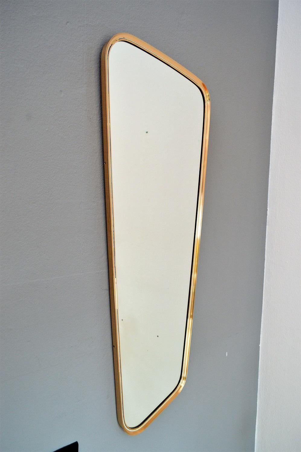 Beautiful and elegant long wall mirror made of full polished brass with the typical design form of the Germany's 1950s.
Made by Vereinigte Werkstätten München in the 1970s.
The brass frame is in perfect order and of high level of craftsmanship