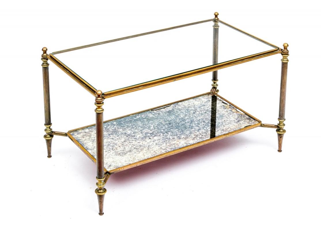 A fine and elegant bronze frame with ribbed columnar legs and shaped tops and legs, with ball finials and peg feet. With an inset .25” fully beveled glass top, the lower tier with angled attachments to hold the inset smoked mirror. The bronze with a