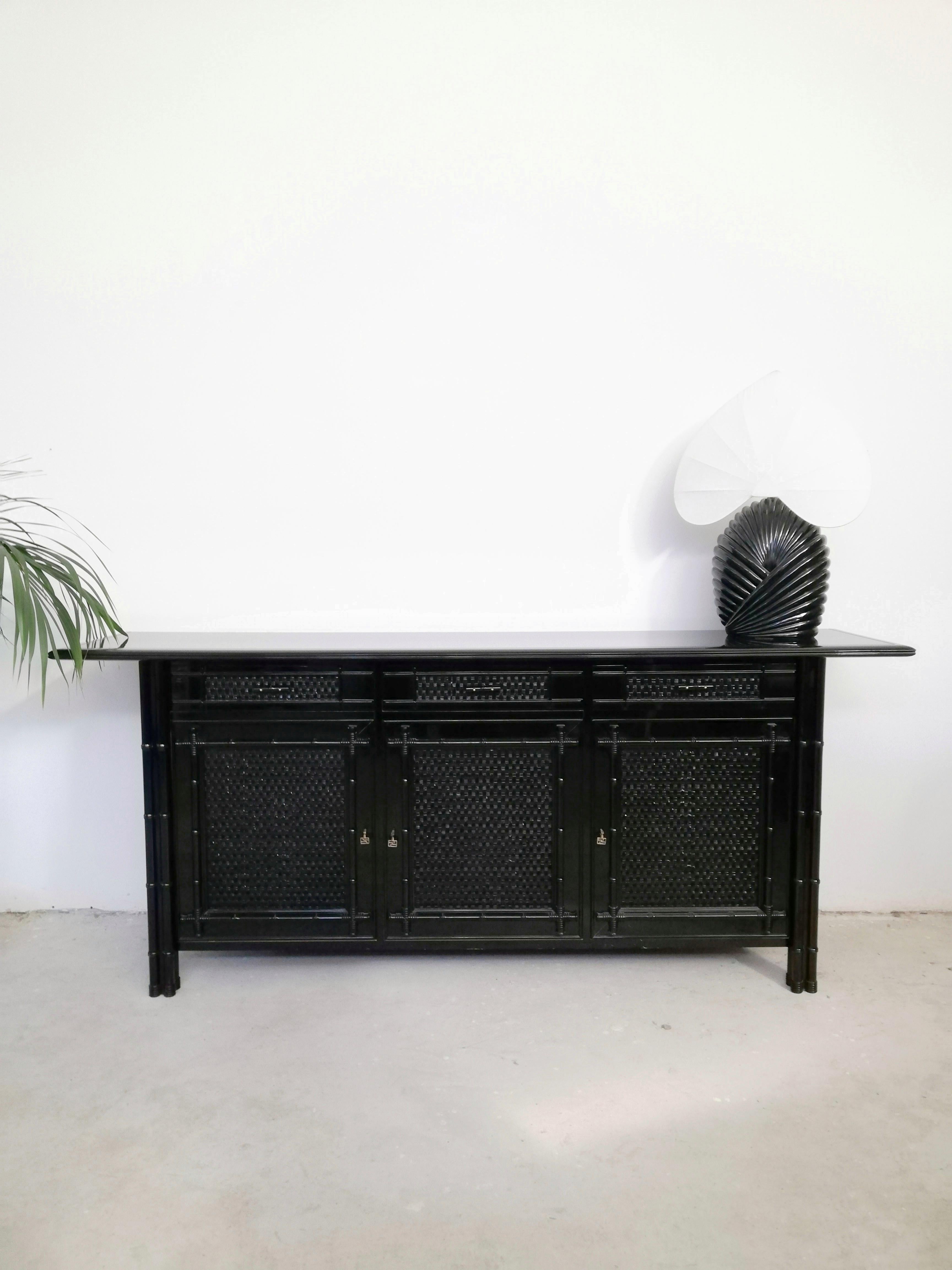Long Buffet or Credenzas but is also perfect as a Consolle, in sleek black high gloss lacquered finish.
It Is made in solid ash wood and covered in wicker and faux bamboo.
This solid and very high quality piece of furniture was made in Italy in