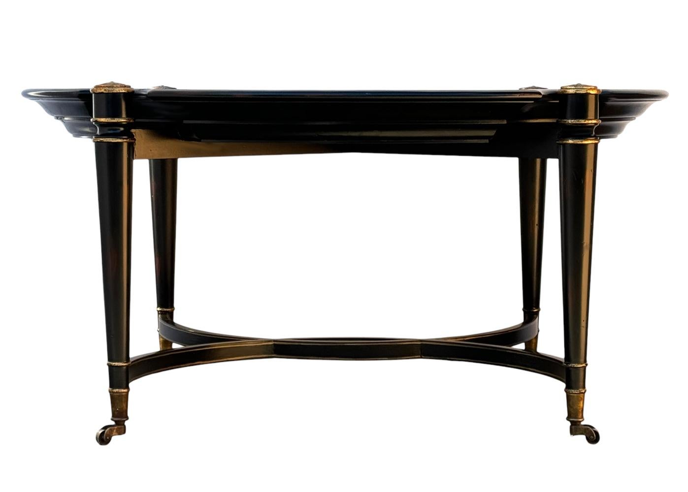 A classic & sophisticated coffee table straight out of the 1980's. It features an emire regency design with burl wood with gold trim. 