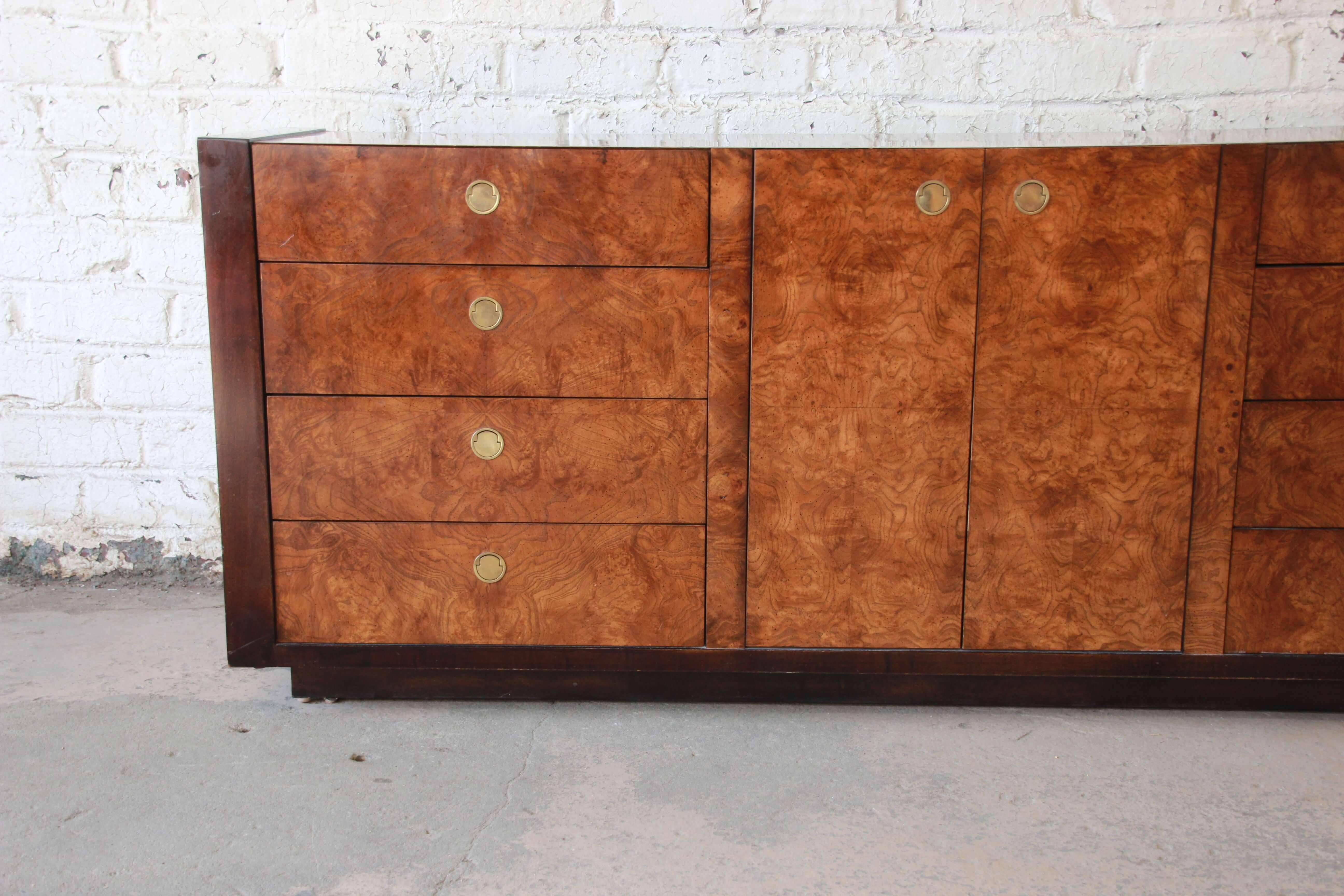 Offering a beautiful Hollywood Regency burled olivewood credenza by Century Furniture. The credenza or dresser offers 12 drawers for ample storage and organization. The drawers have nice brass pulls with drawers that open and close smoothly. The
