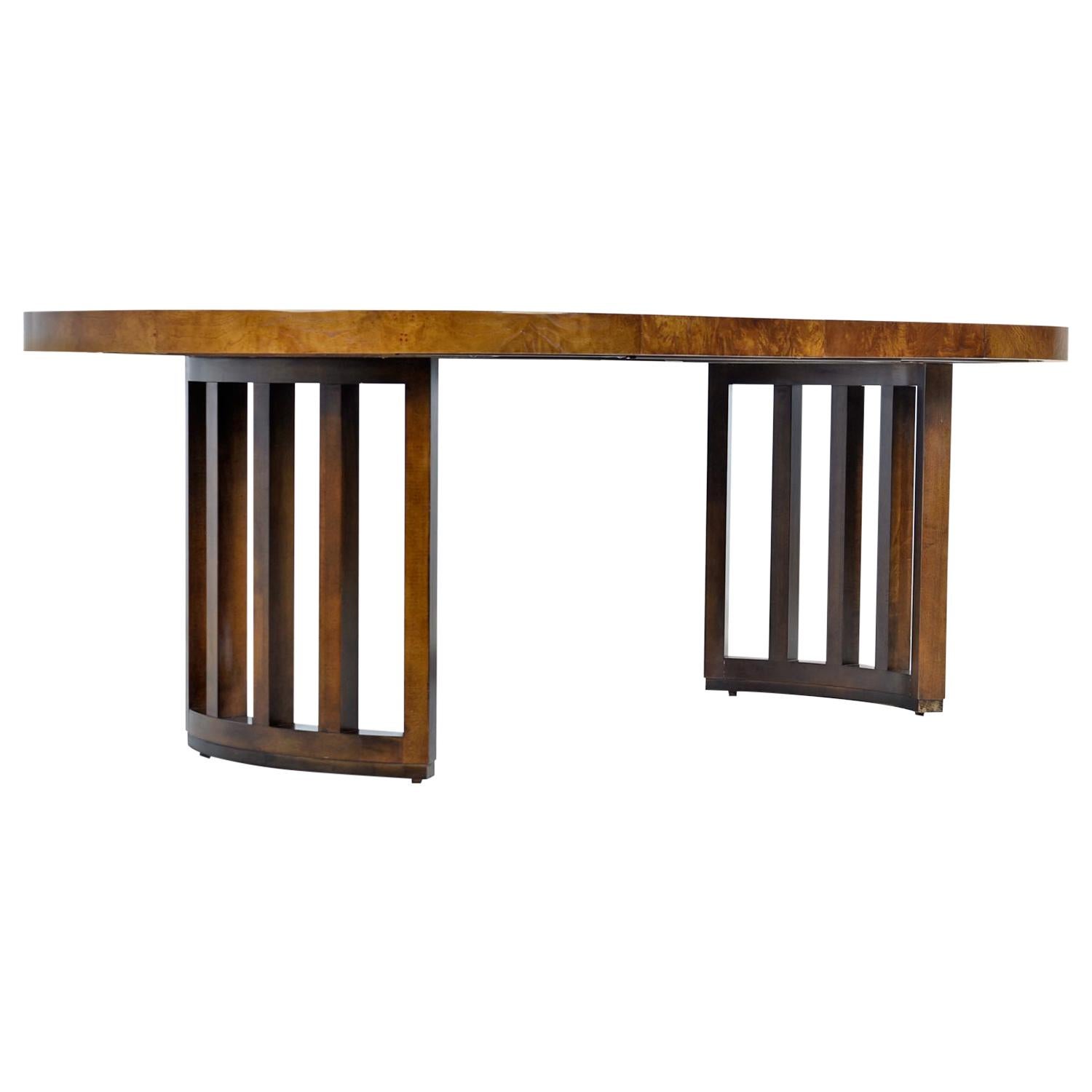 Stunning and large elliptical dining table made by esteemed US furniture maker century, circa 1970s. Smothered in iridescent burl olive wood that flows over onto the stout edge band. The stylish, architectural cage pedestal base not only mimics the