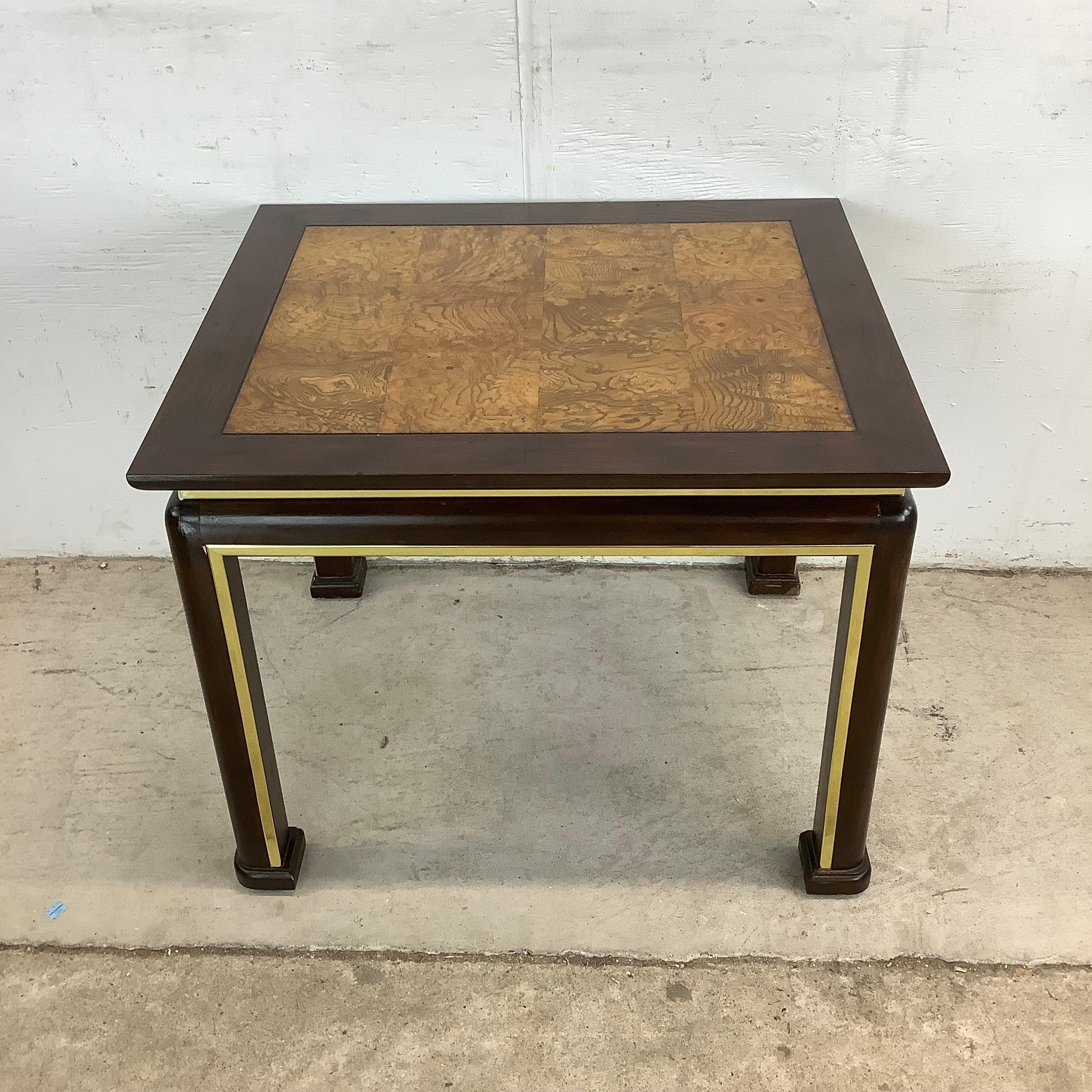 Dieser auffällige Beistelltisch im Vintage-Stil vereint die Eleganz des modernen Designs der Jahrhundertmitte mit dem Glamour der Hollywood Regency-Details. Die quadratische Platte mit Wurzelholzfurnier im Parkettmuster strahlt Wärme, Struktur und