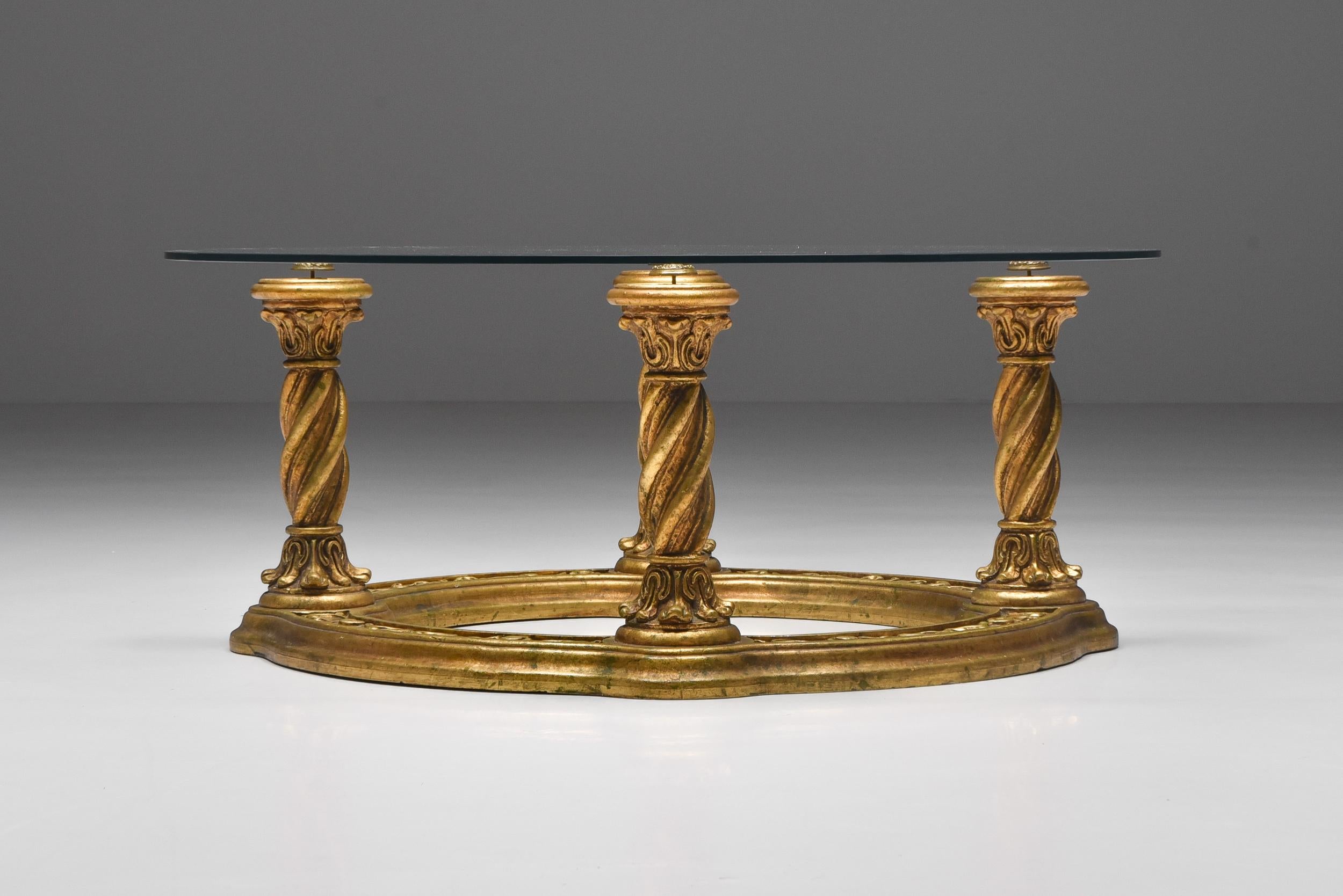 Baroque giltwood carved Regency style coffee table. Glass top with brass details, made in Belgium, the 1940s. Would look good in an eclectic interior.
 