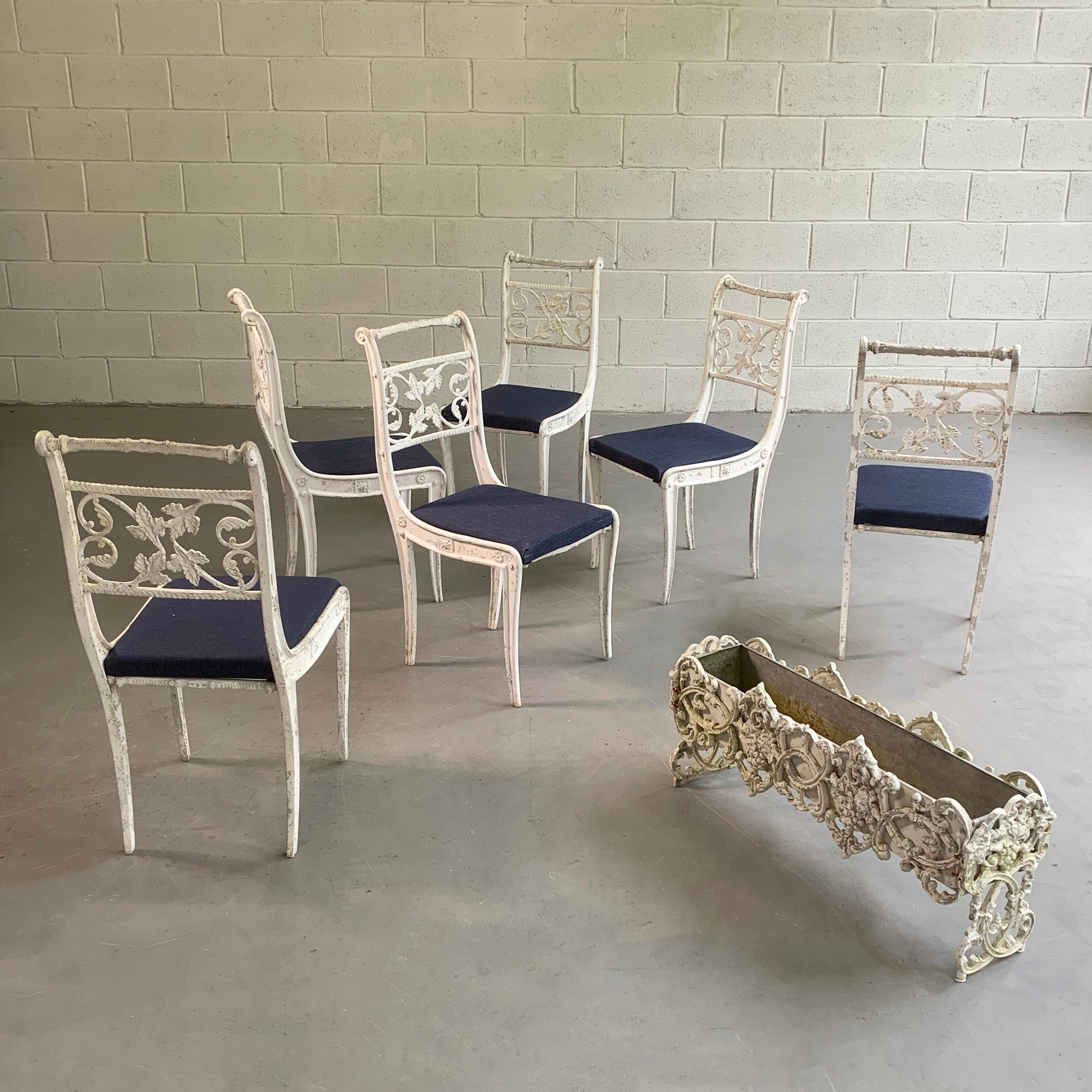 Set of 6, Hollywood regency, outdoor, patio, garden chairs feature cast aluminum and zinc frames, enameled in white with upholstered seats in a contrasting navy outdoor fabric. The planter shown is listed separately.