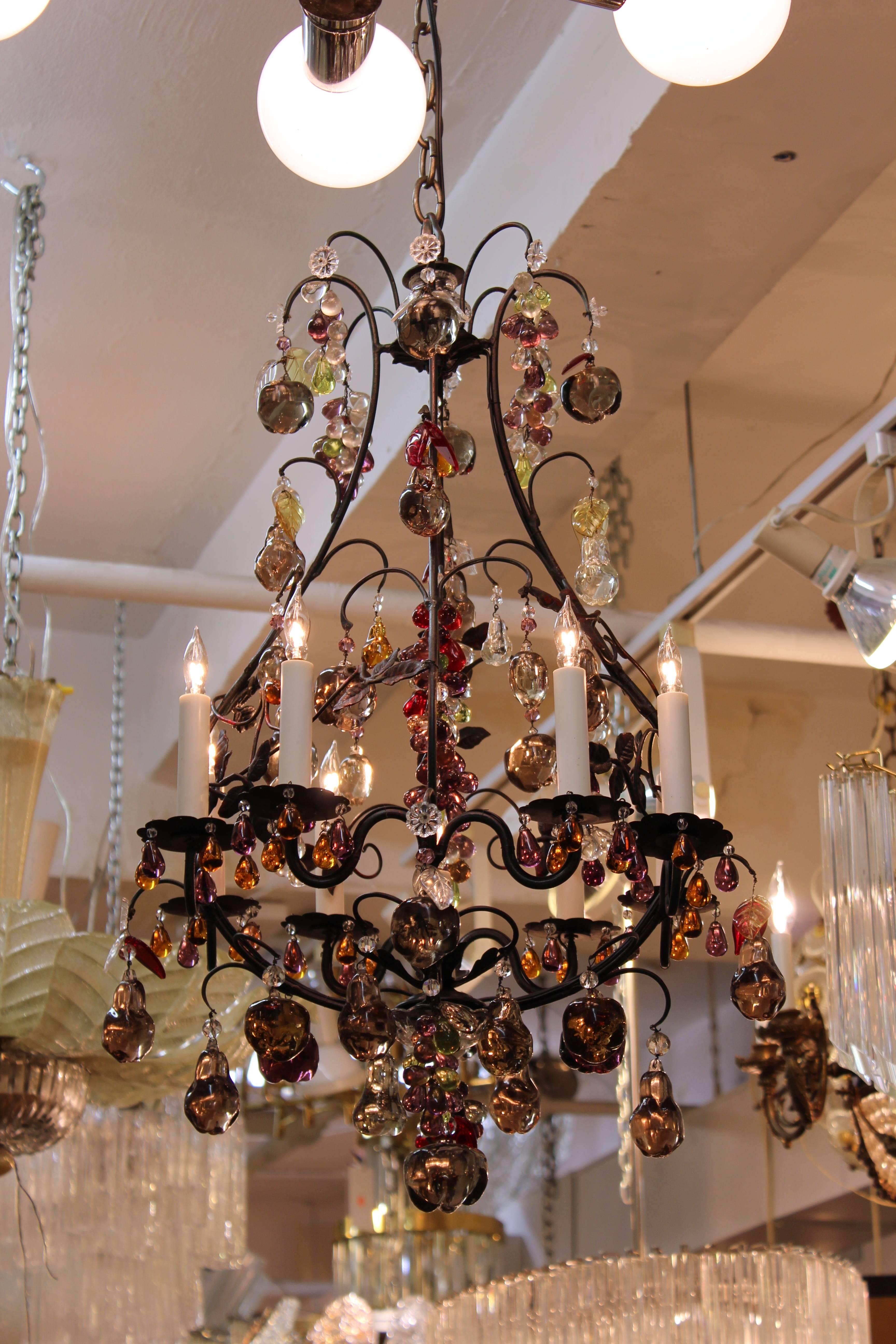 A Hollywood Regency style chandelier with a metal frame and multicolored crystal fruit pendants. The piece is in great condition.