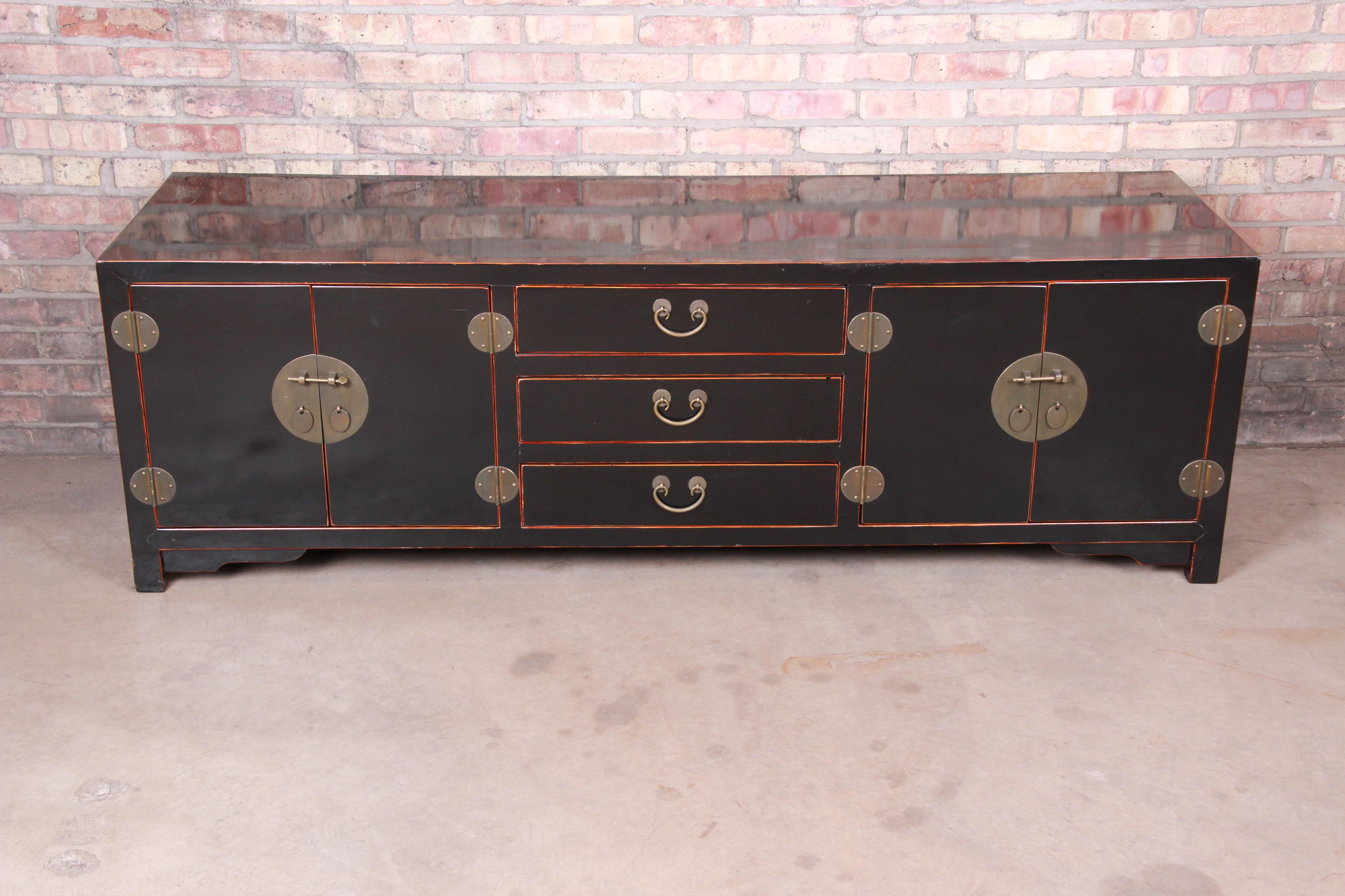 A gorgeous Hollywood Regency chinoiserie sideboard credenza or bar cabinet

20th century

Black lacquered wood, with original Asian-inspired brass hardware.

Measures: 74.75