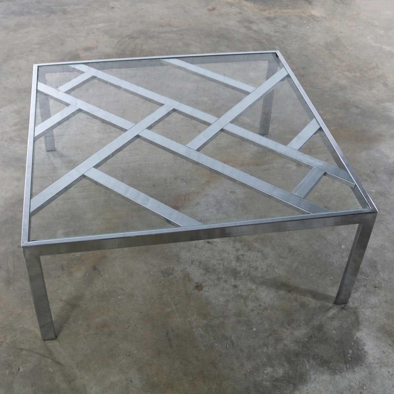Handsome Hollywood Regency chrome square coffee table with glass insert top. This table has overtones of Milo Baughman mixed with Chinese Chippendale style lattice design. It is in wonderful vintage condition overall. The chrome has been polished