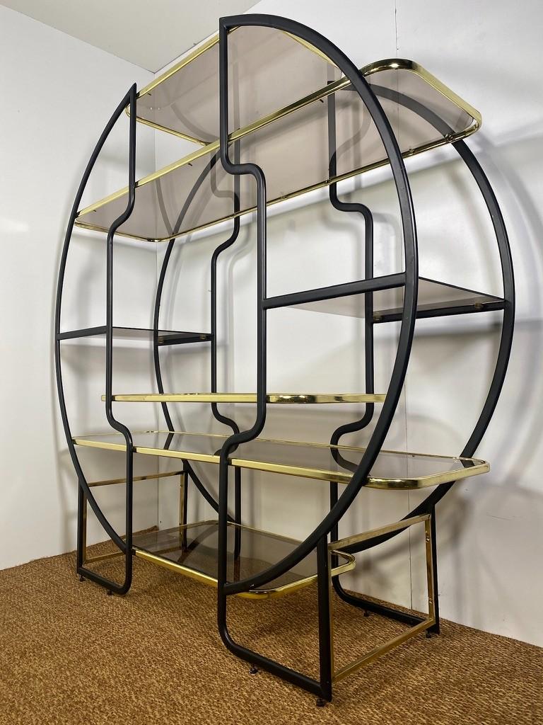 Beautiful Maison Jansen style circular étagère or vitrine with seven tempered smoked glass shelves in a frame of gold and black lacquered metal. Highly decorative; a nimpressive eye catcher in any interior. Also to be used as a roomdivider. 

It's