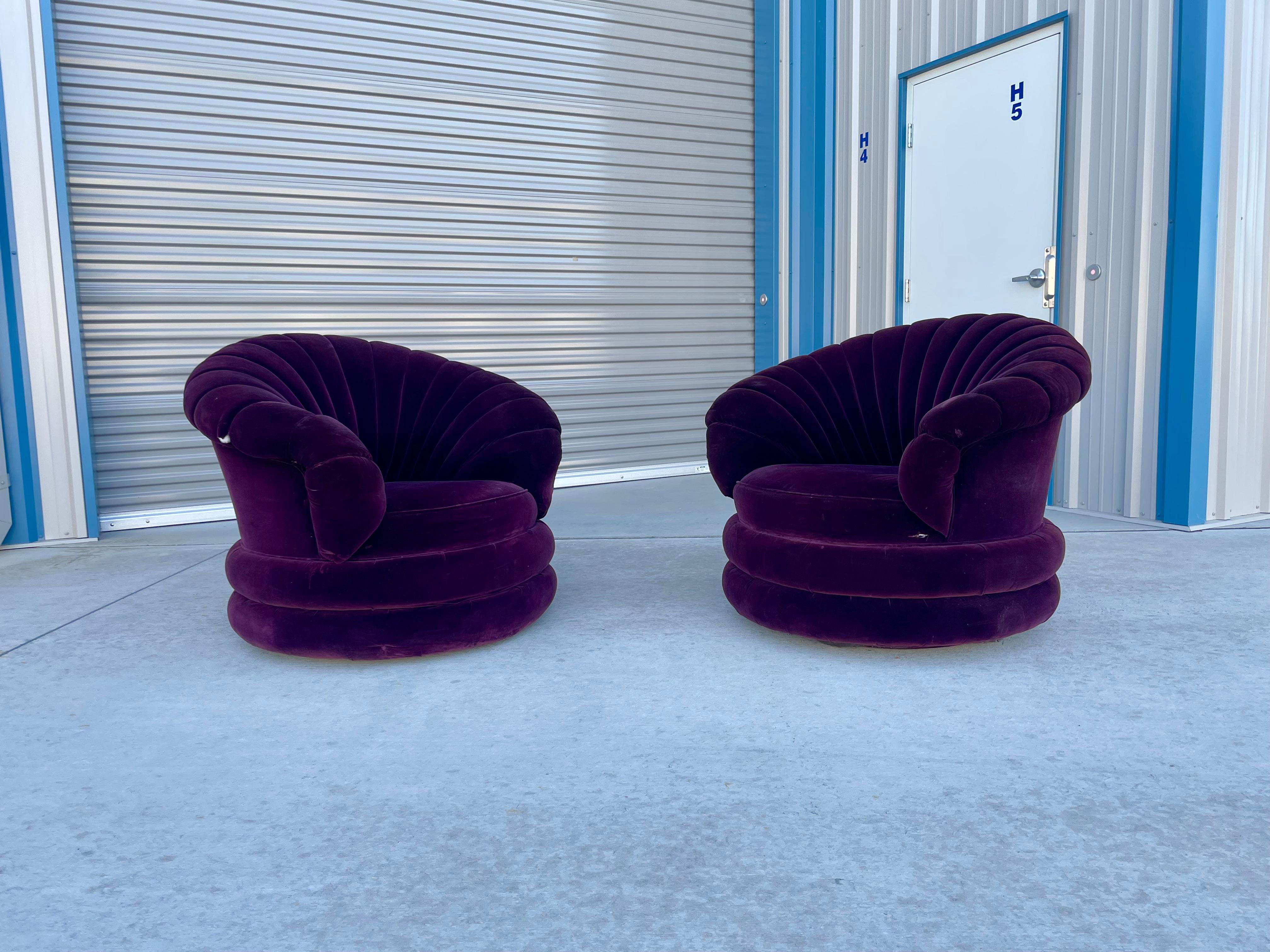 Beautiful vintage clamshell swivel chairs designed and manufactured in the United States circa 1960s. These beautiful chairs feature a swivel base that rotates 360 degrees. The chairs also feature purple suede upholstery with a unique clamshell