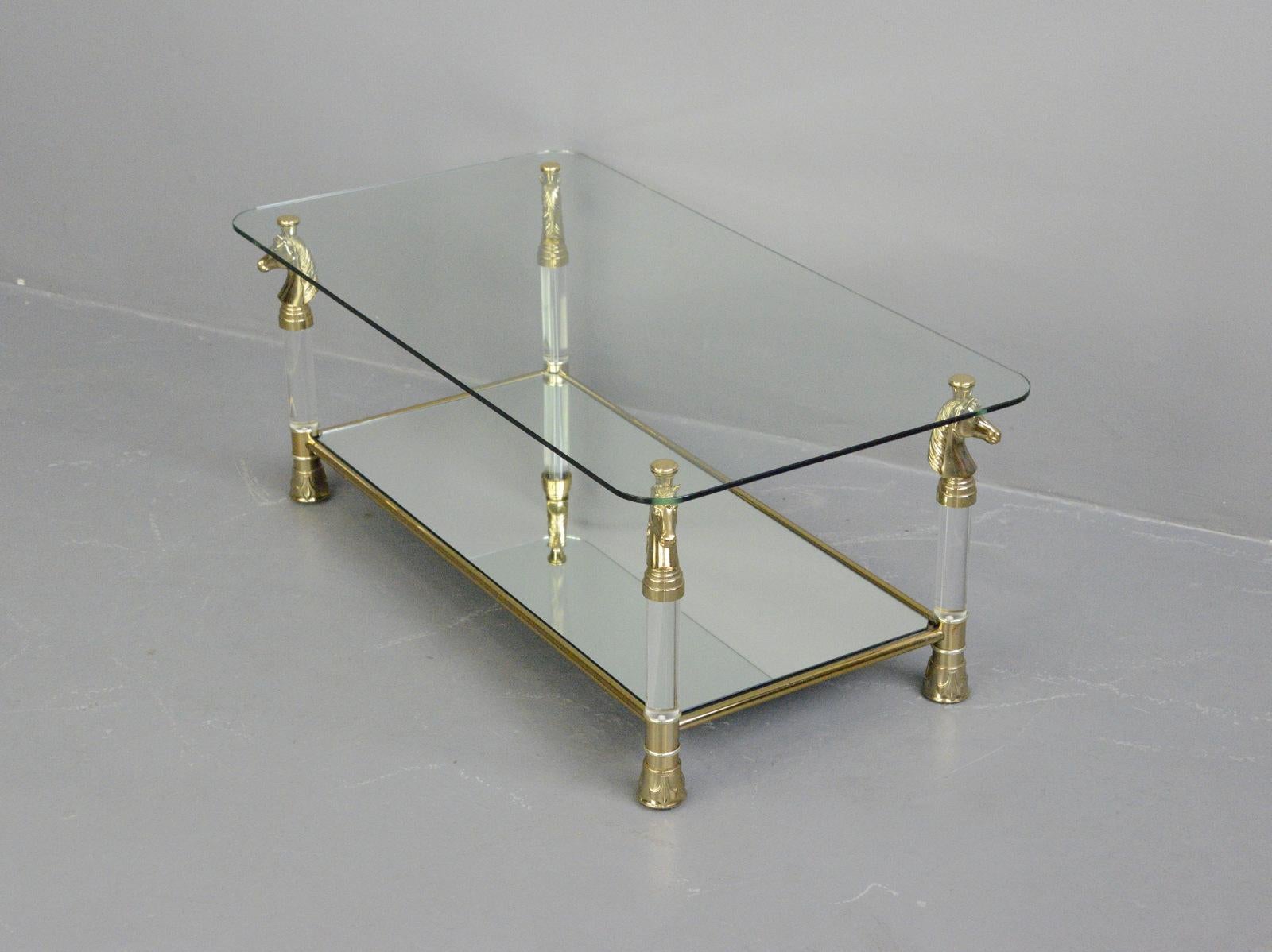 Hollywood Regency coffee by Maison Charles Paris table, Circa 1970s

- Lucite legs with brass horses
- Brass feet with fleur de lis detailing
- Toughened mirror glass shelf
- Toughened glass top
- French ~ 1970s
- Measures: 105cm long x 55cm