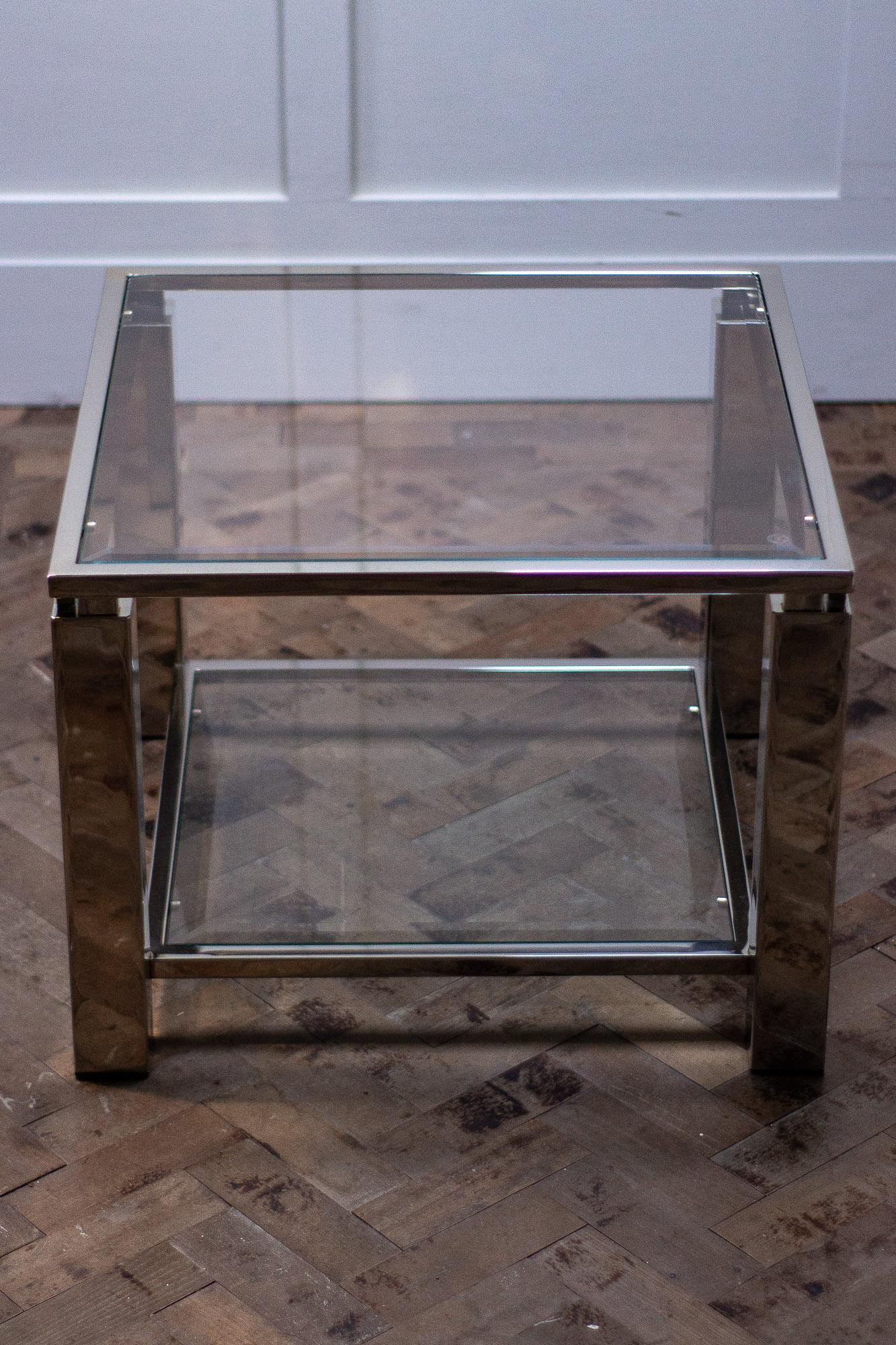 Midcentury coffee table in the Hollywood Regency style.

This chrome metal table has two panels of bevelled glass, one as the top and one as the lower shelf. 
Measures:
Height 45 cm
Width 60 cm
Depth 60 cm.
 