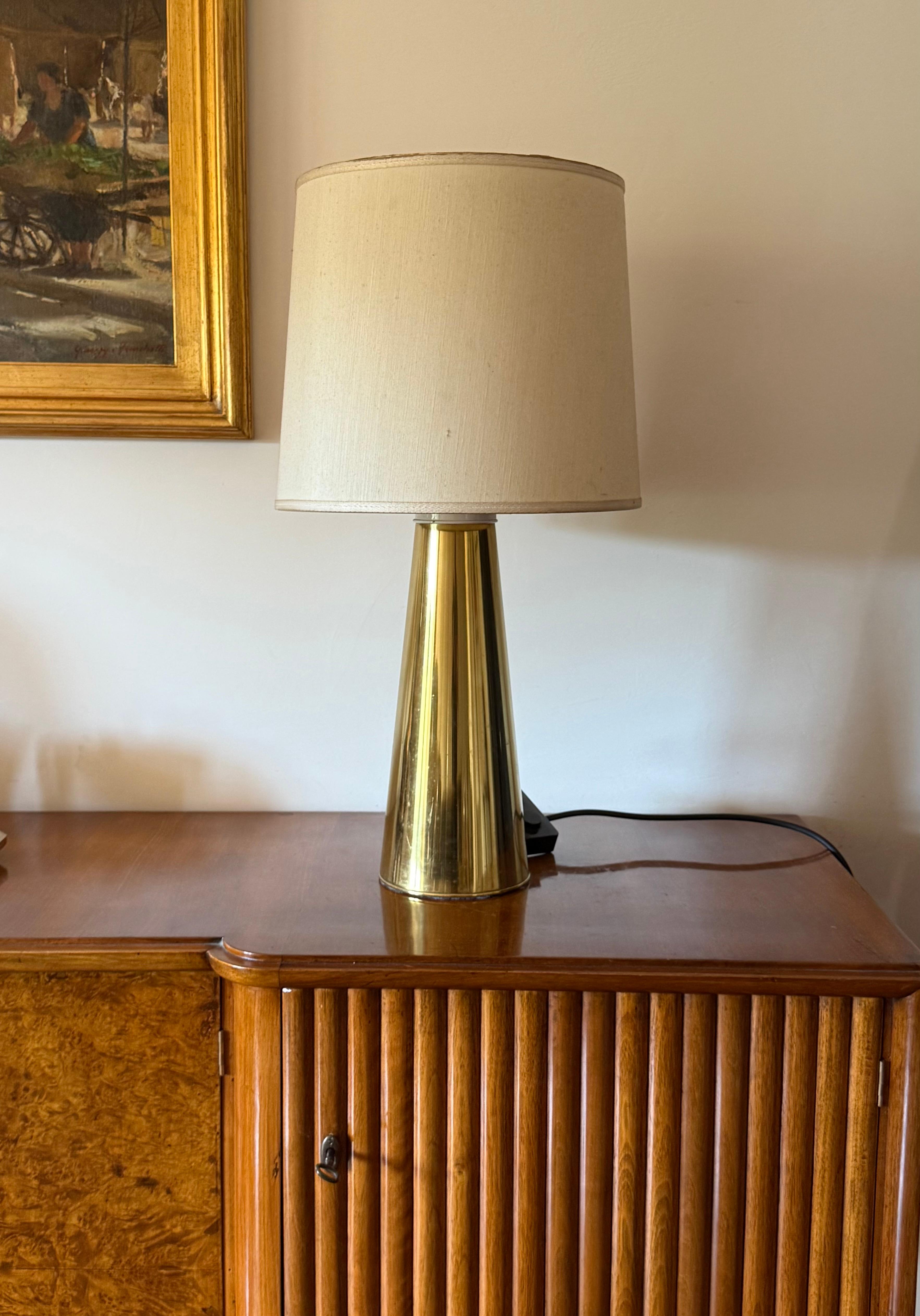 Lampe de table conique en laiton Hollywood regency

Italie, années 1970

H 67 cm - 30 cm diam.

Ampoules triples.

Abat-jour inclus.

État : très bon, conforme à l'âge et à l'utilisation. Défauts sur l'abat-jour