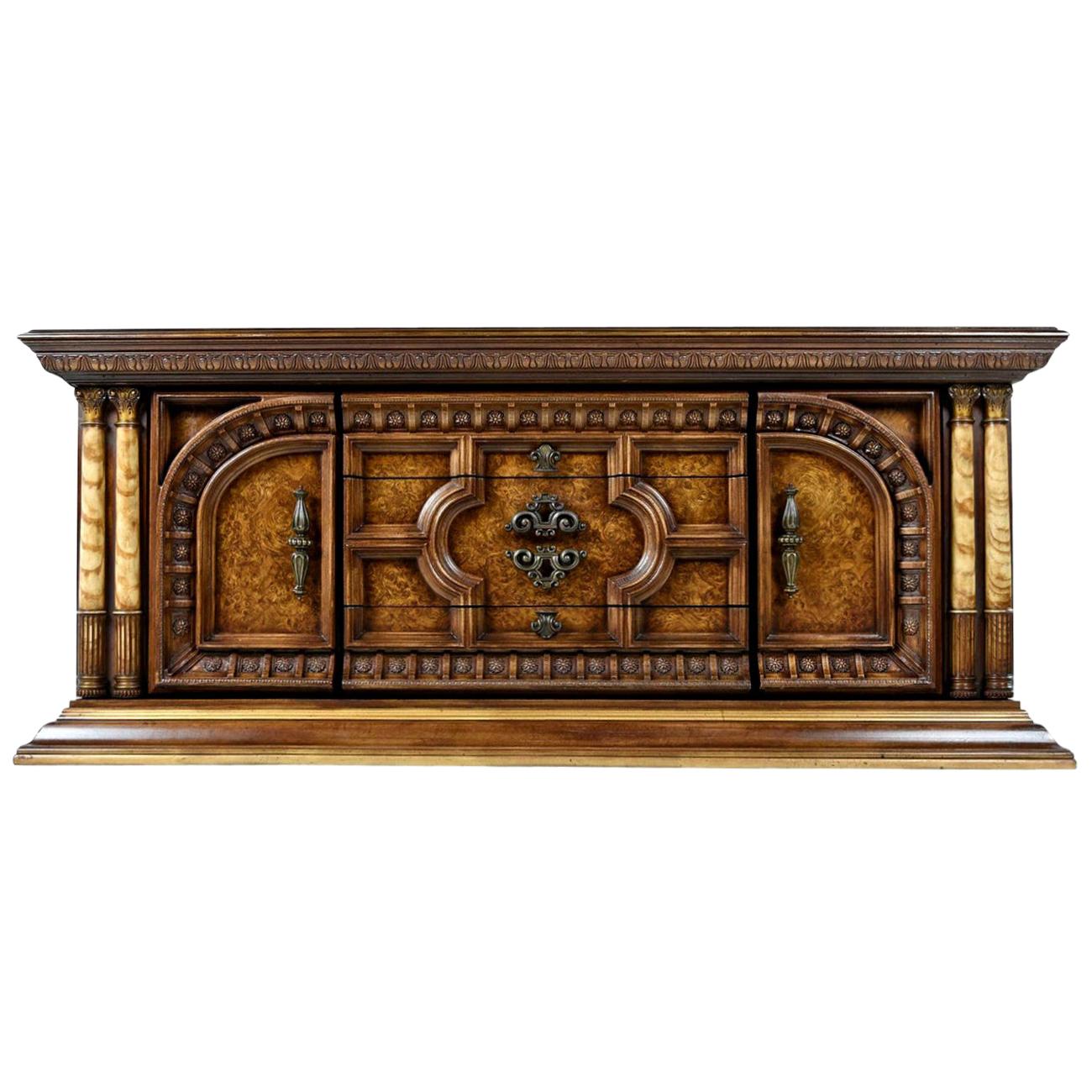 This burl wood adorned dresser reminds us of the phenomenal architecture possessed by the great monuments from Greek antiquity which adorn the Acropolis. The aged brass handles and faux ivory pillars add a splash of glitz and glamour which further