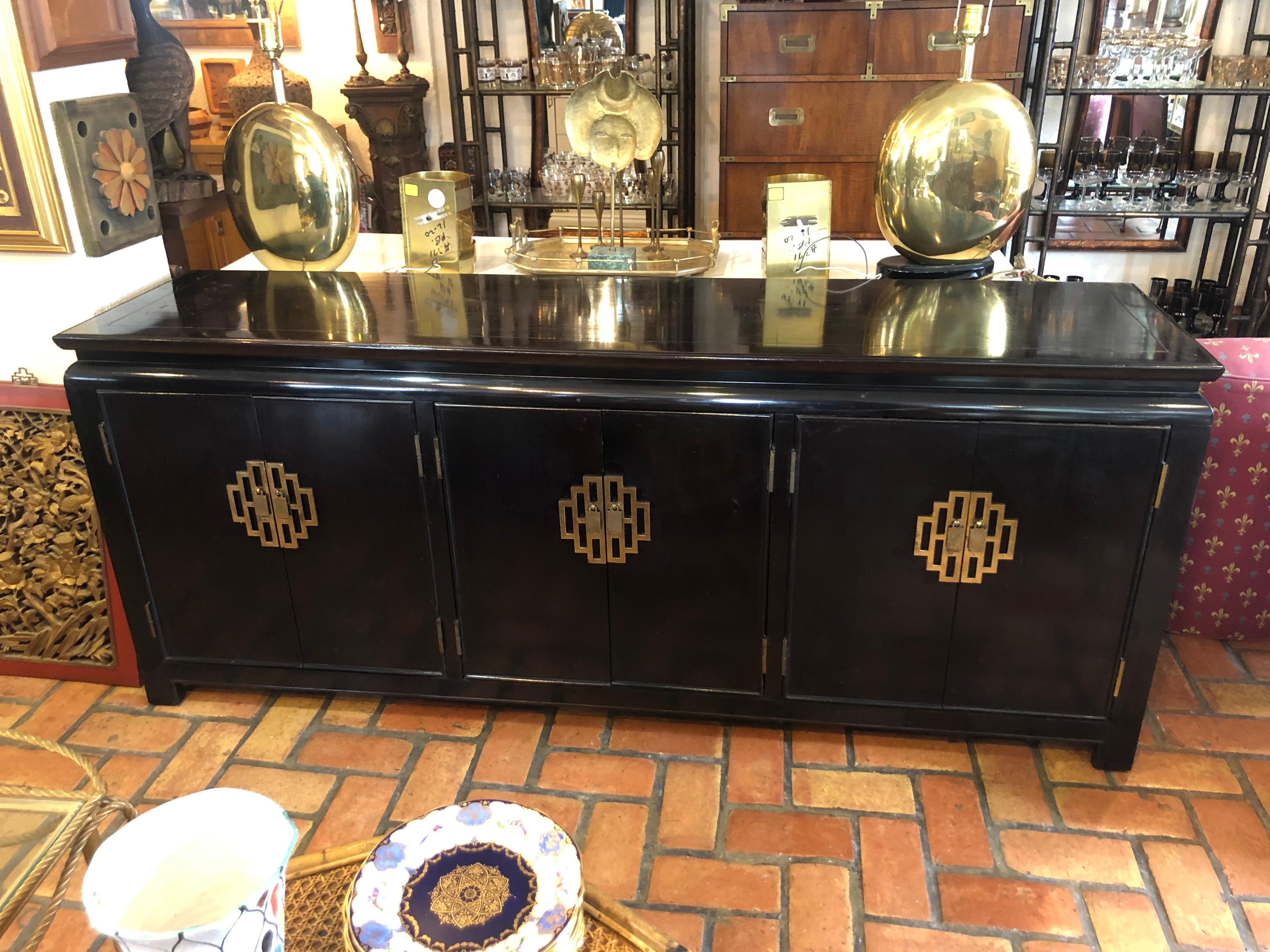 Hollywood Regency Credenza in the style of James Mont. This sophisticated black lacquered beauty by Century would upgrade any room with its presence. Lots of storage and nice heavy brass hardware.