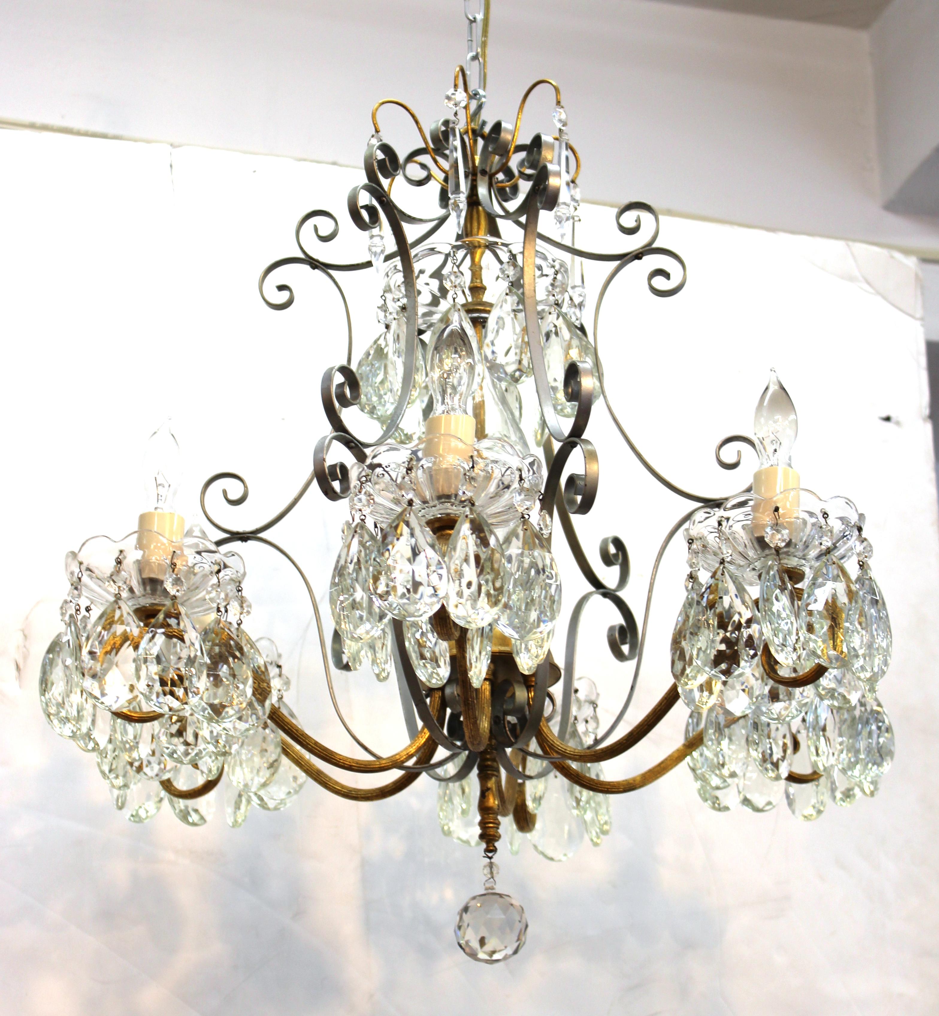 Hollywood Regency crystal chandelier with wrought metal frame and gilt structural accents. The piece takes six candelabra base bulbs and is in great vintage condition.