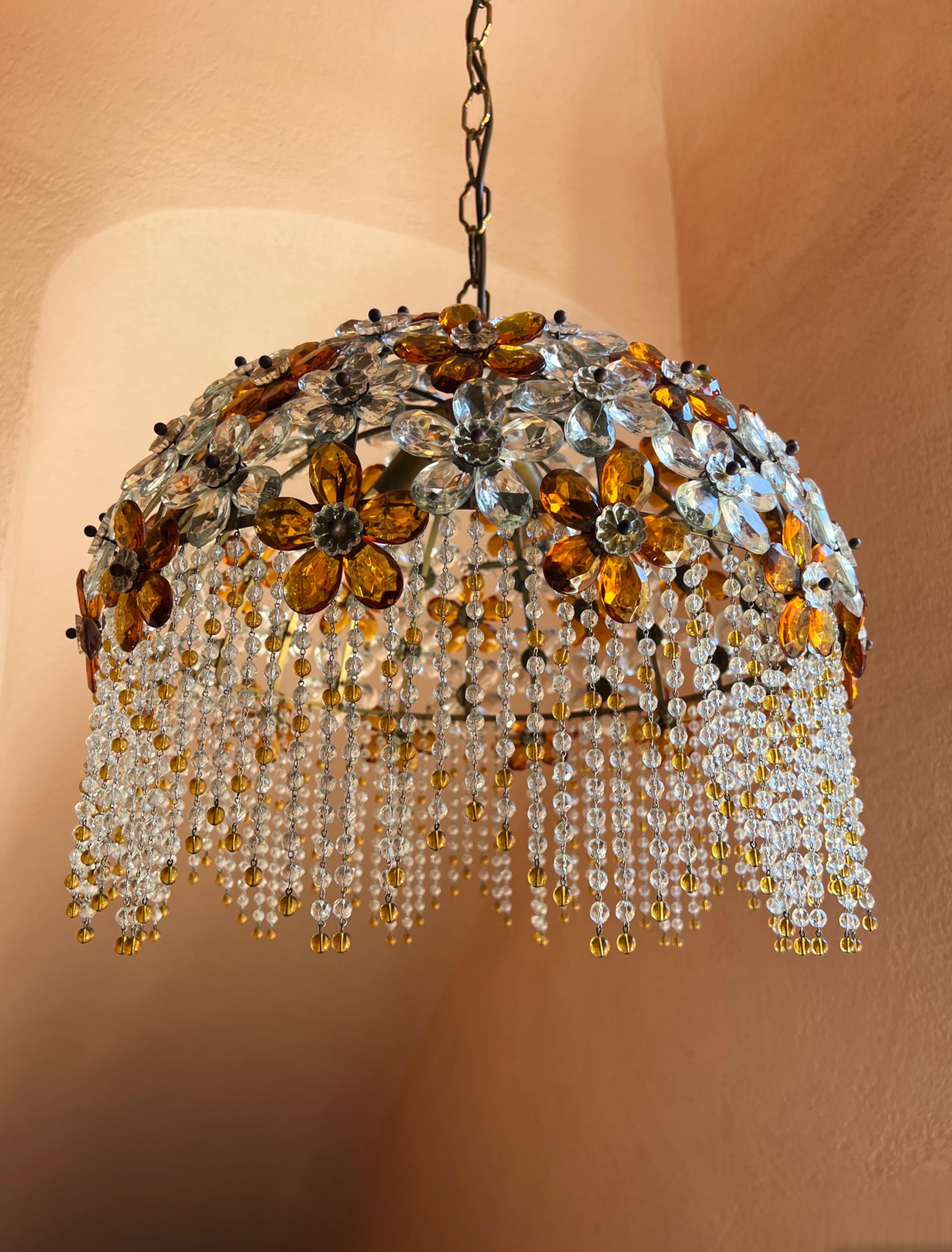 Lampadario della rinomata Maison francese Baguès. Risalente agli anni '60, questo squisito pezzo è caratterizzato da petali di cristallo color ambra e trasparente che creano delicati fiori. Sono montati su una struttura in metallo. Dotato di tre