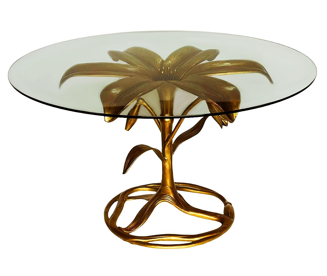 A classic Lily large dining table or center table by Arthur Court. It features a gold colored solid aluminum base with a thick clear glass top. A very clean example without any issues to note. 