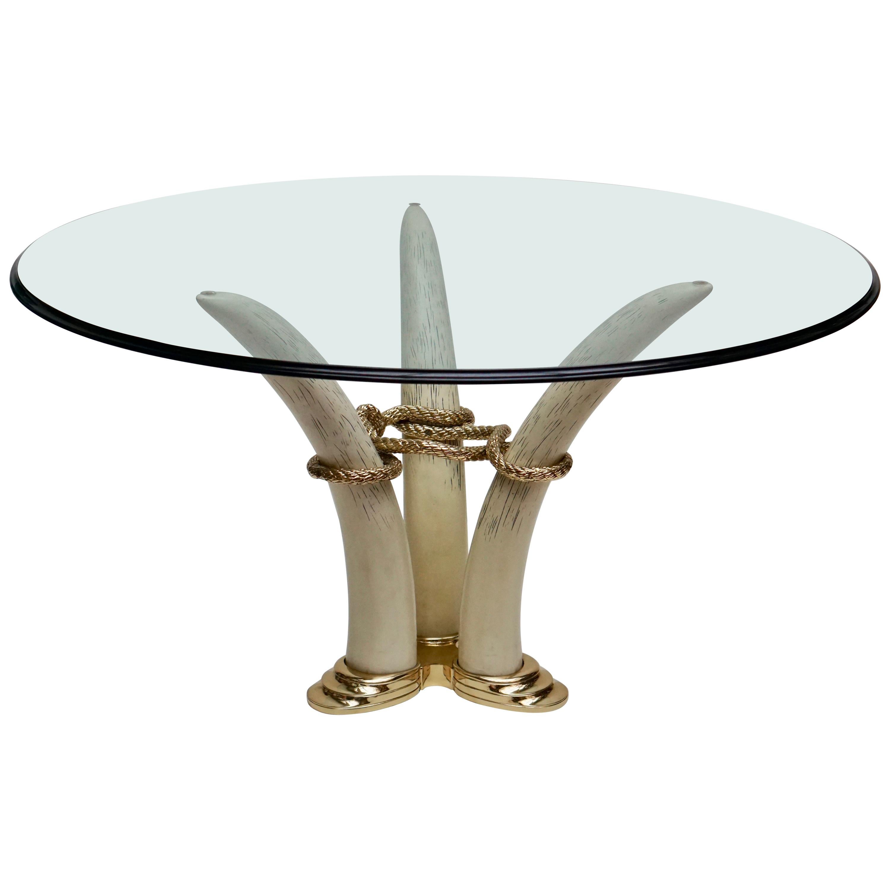 Dining table in gilded bronze and resin in imitation of tusks linked together by a rope.
Measures: Diameter glass 140 cm.
Height 74 cm.
Diameter tusk 80 cm.


 