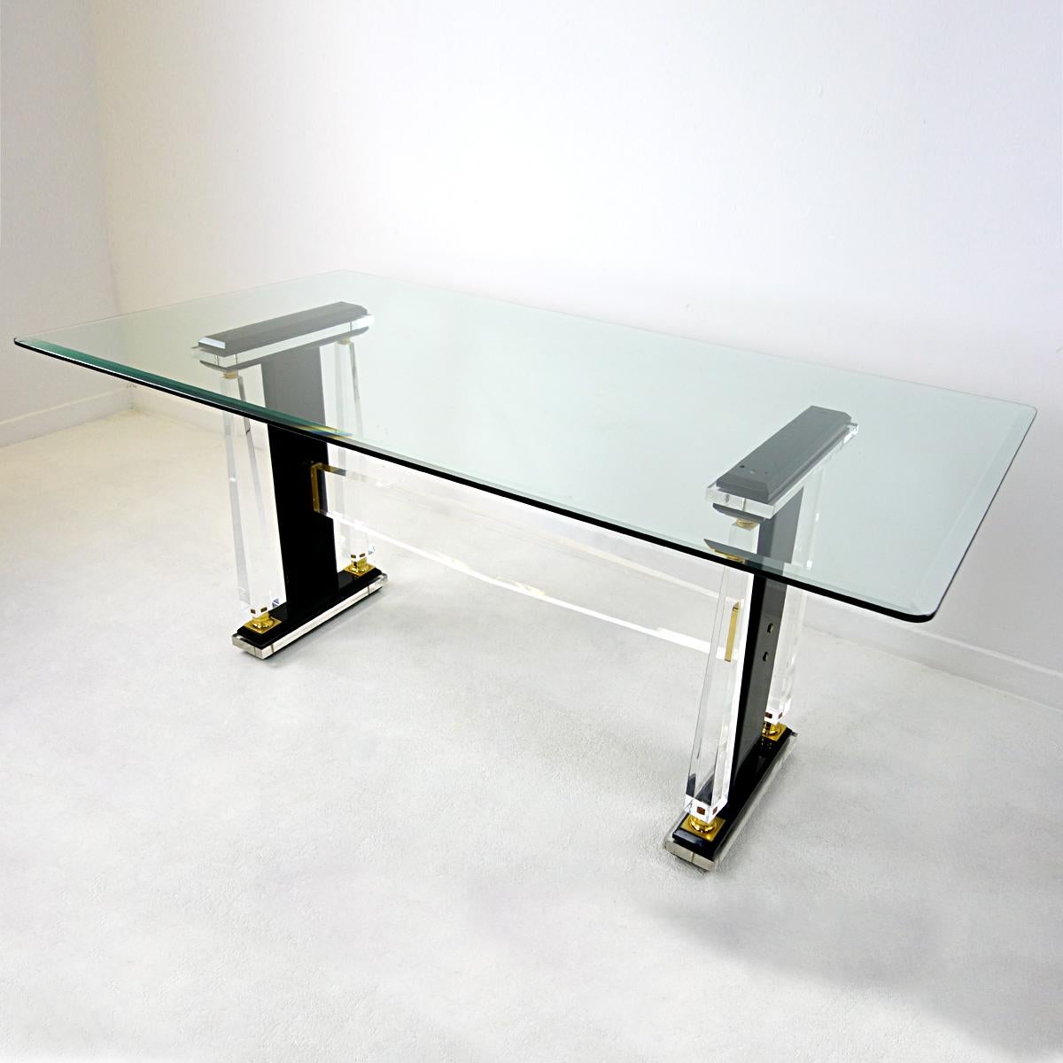 Stunning rectangular dining table in Hollywood Regency style.
Its top is made of glass that has rounded corners. It sits on the frame without being attached. The edges of the glass are cut all around. The frame is made of transparent and black