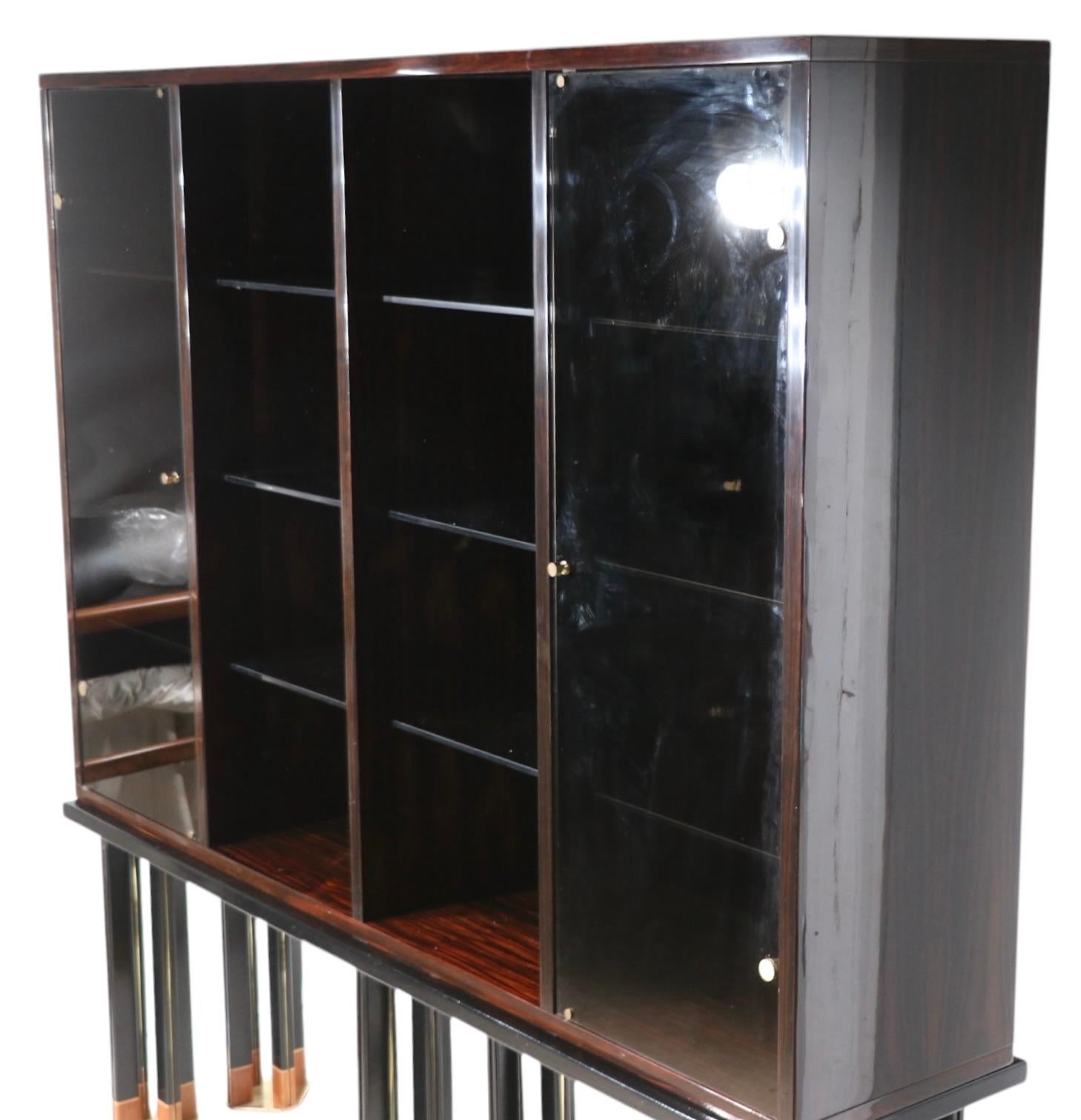 Exceptionnelle vitrine de style Hollywood Regency, Art Deco Revival, conçue par Paolo Barracchia, pour Roman Deco, vendue par Artebella 8687 Melrose Ave LA Ca. circa 1984. La caisse présente un placage en bois exotique, des portes battantes en verre