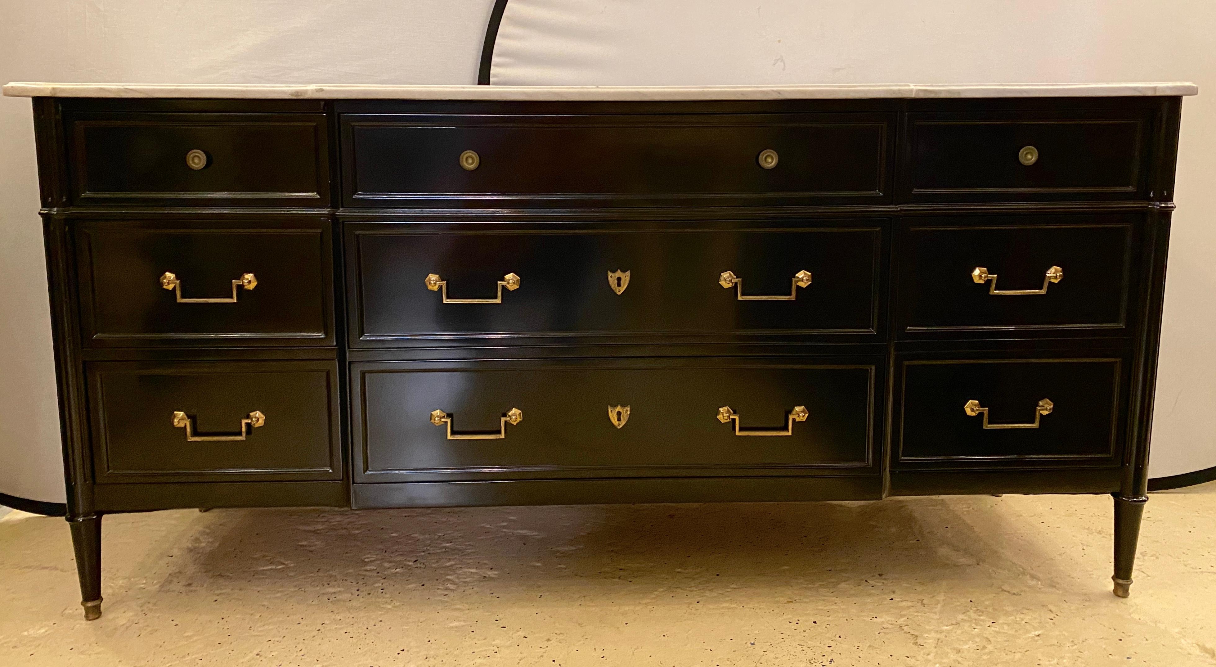 Finest Hollywood Regency dresser or commode with a white marble top in the Maison Jansen style having a spectacular Steinway piano black lacquered finish. The three boxed center large drawers flanked by sets of three smaller drawers all having the