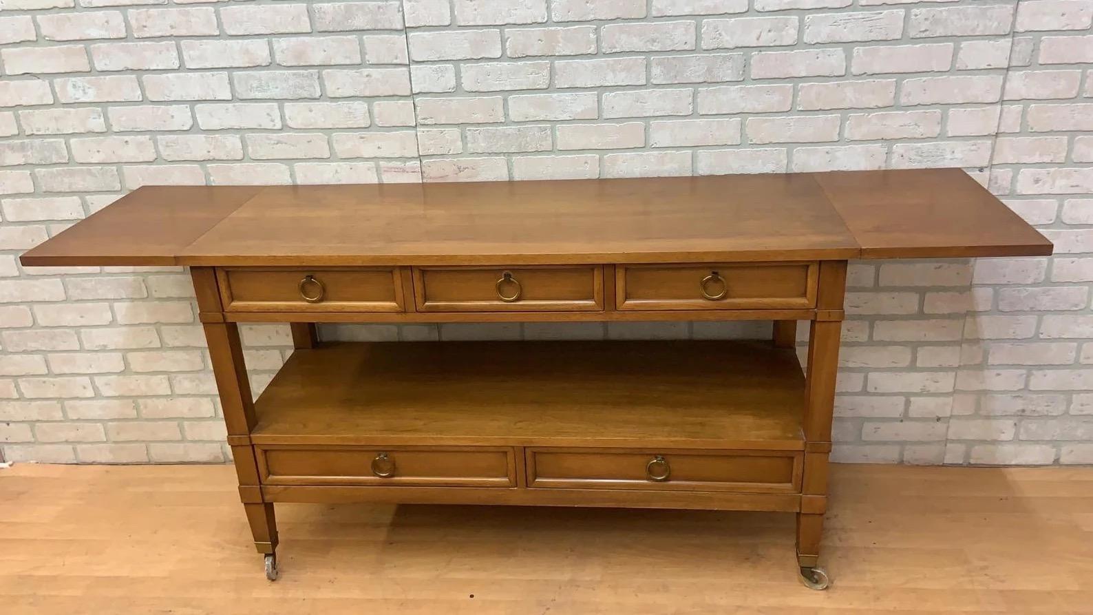 Hollywood Regency Drop Leaf Rolling Bar Server with Drawer Storage by Sleigh Furniture

Sleigh Furniture bistro style buffet or serving table with 5 drawers on brass casters and a full body lower tier. Leaves extended option allows for full 71