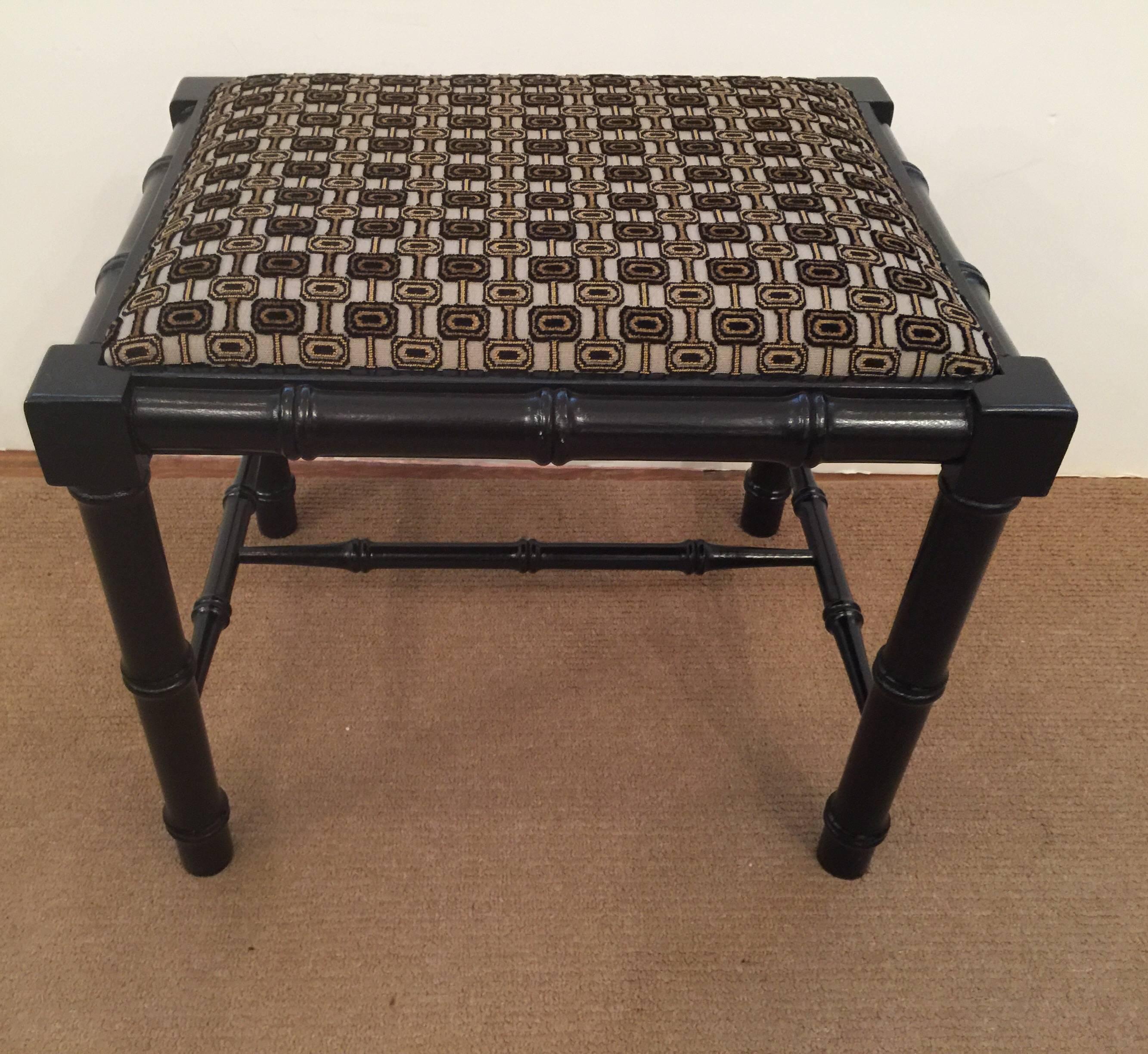 Midcentury Hollywood Regency upholstered bench with ebonized frame. The new fabric in retro pattern in black and taupe with a light grey background.