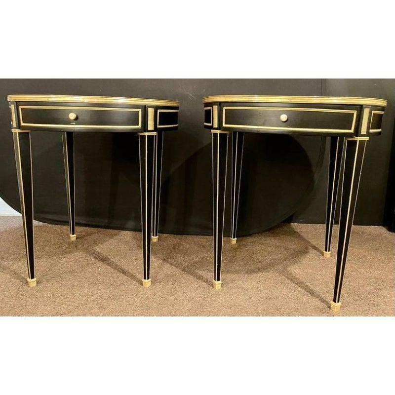 A pair of Jansen style Louis XVI fashioned end or gueridon tables. Each having a bronze framed mirrored top sitting on a single drawer bronzed framed apron with cookie cutter corners. The whole having long sleek tapering legs with bronze framed